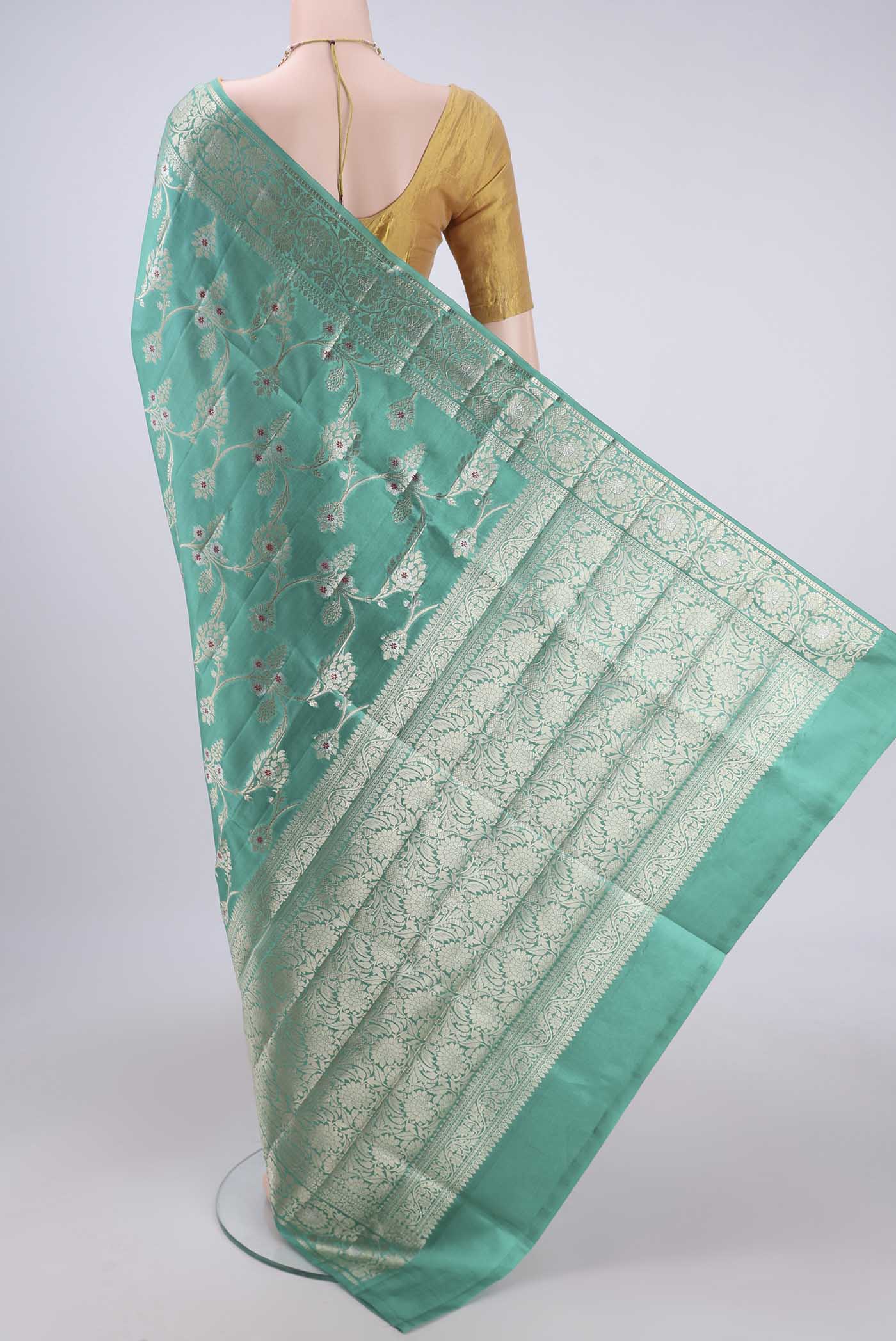 Flat view of Sea Green Banarasi Raw Silk Saree with Zari Butta on the body and Zari Border. 