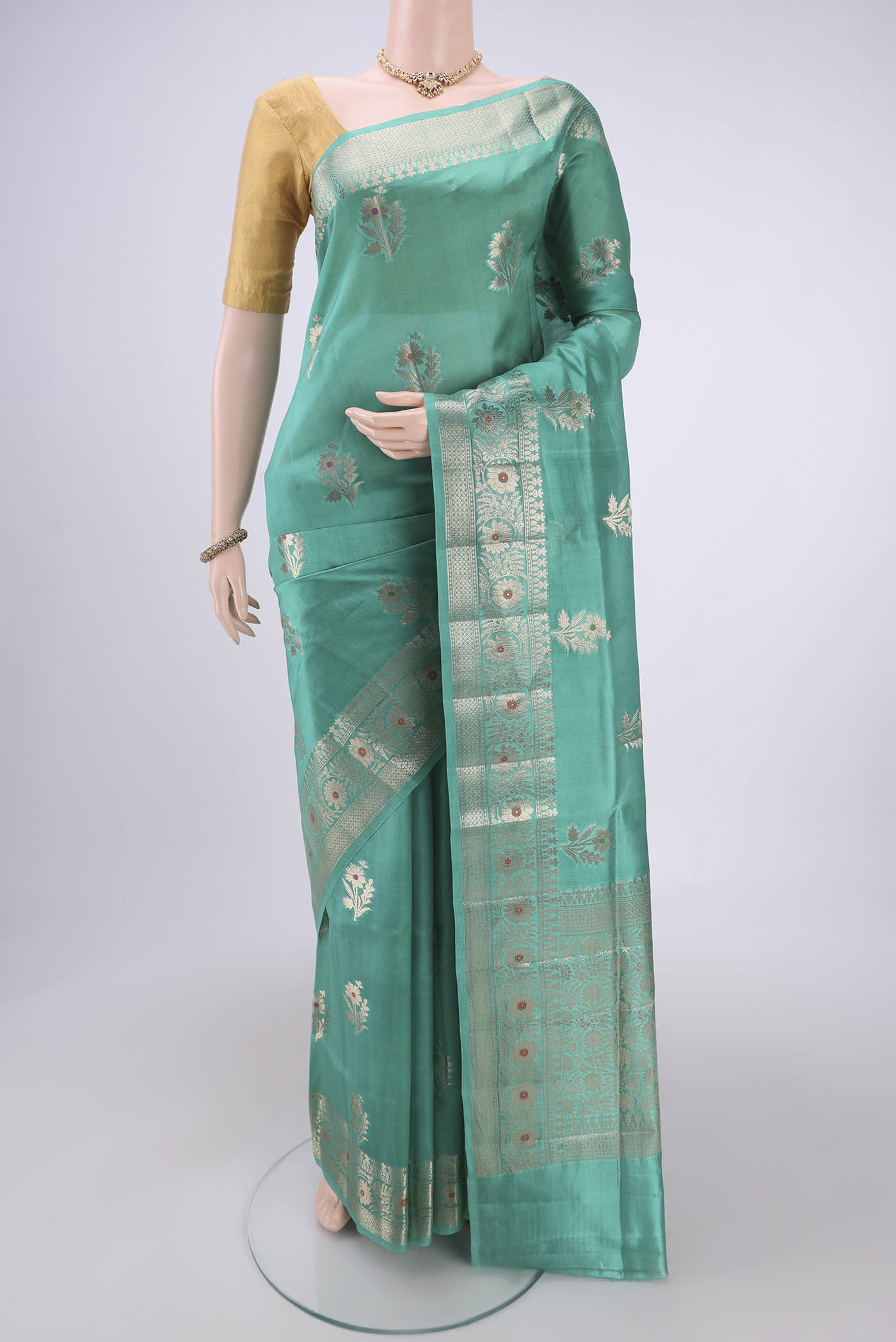 Sea Green Banarasi Raw Silk Saree with Zari Butta on the body and Zari Border.  displayed on a mannequin