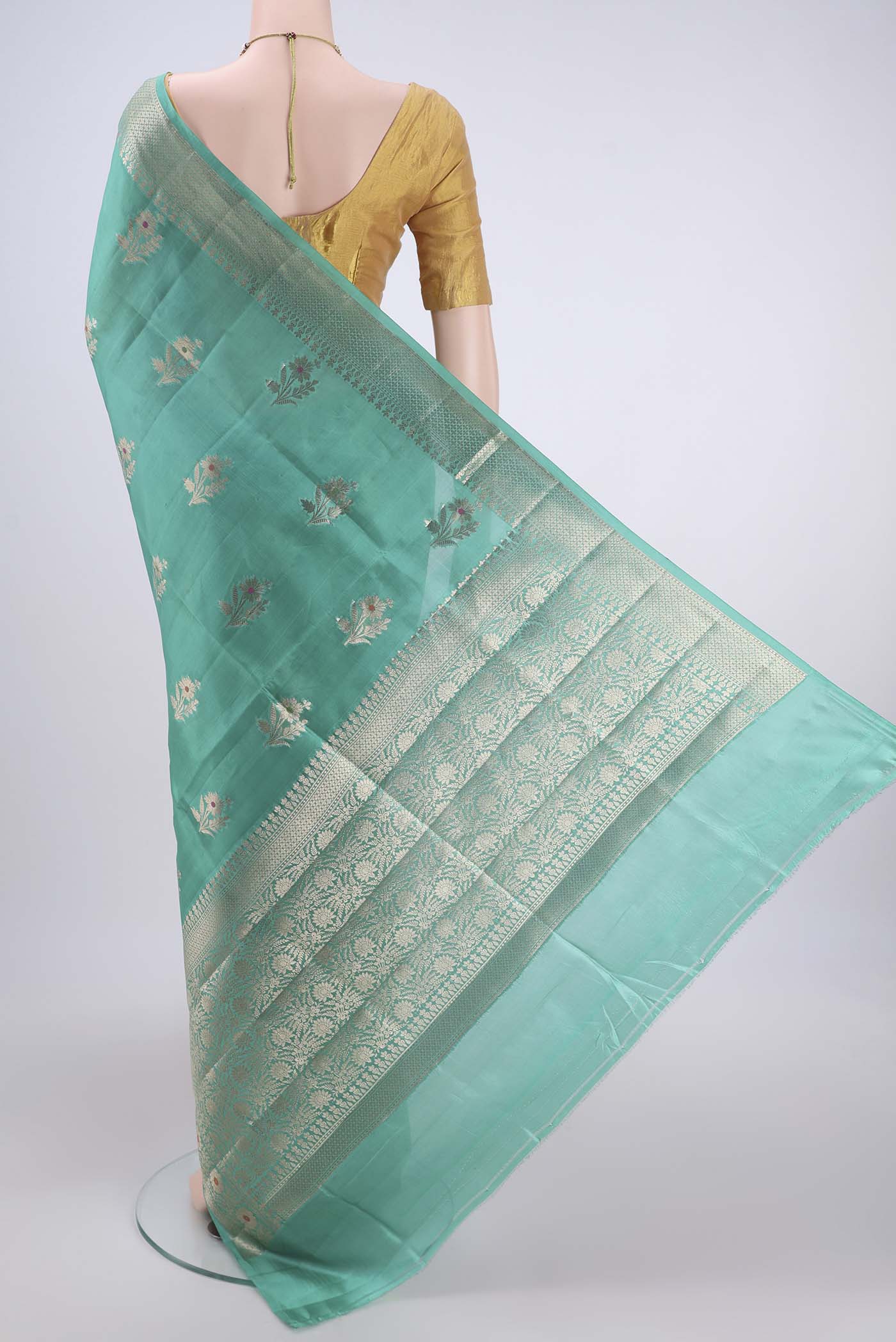 Flat view of Sea Green Banarasi Raw Silk Saree with Zari Butta on the body and Zari Border. 