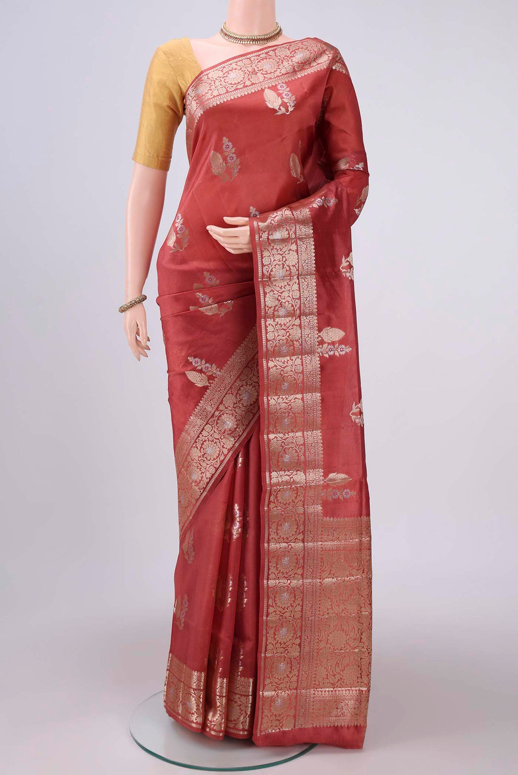 Rust Banarasi Raw Silk Saree with Zari Butta on the body and Zari Border.  displayed on a mannequin