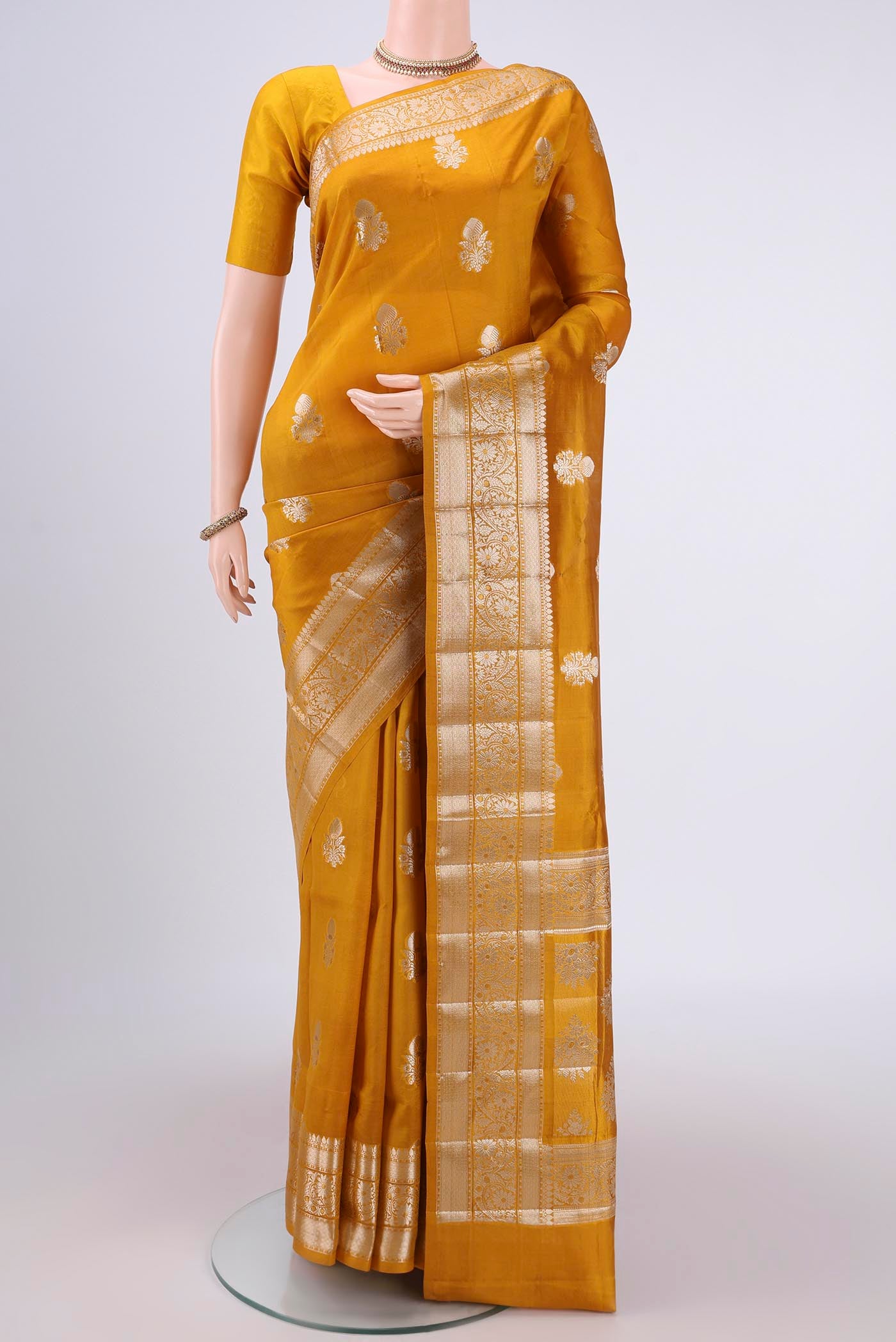 Yellow Banarasi Raw Silk Saree with Zari Butta on the body and Zari Border.  displayed on a mannequin