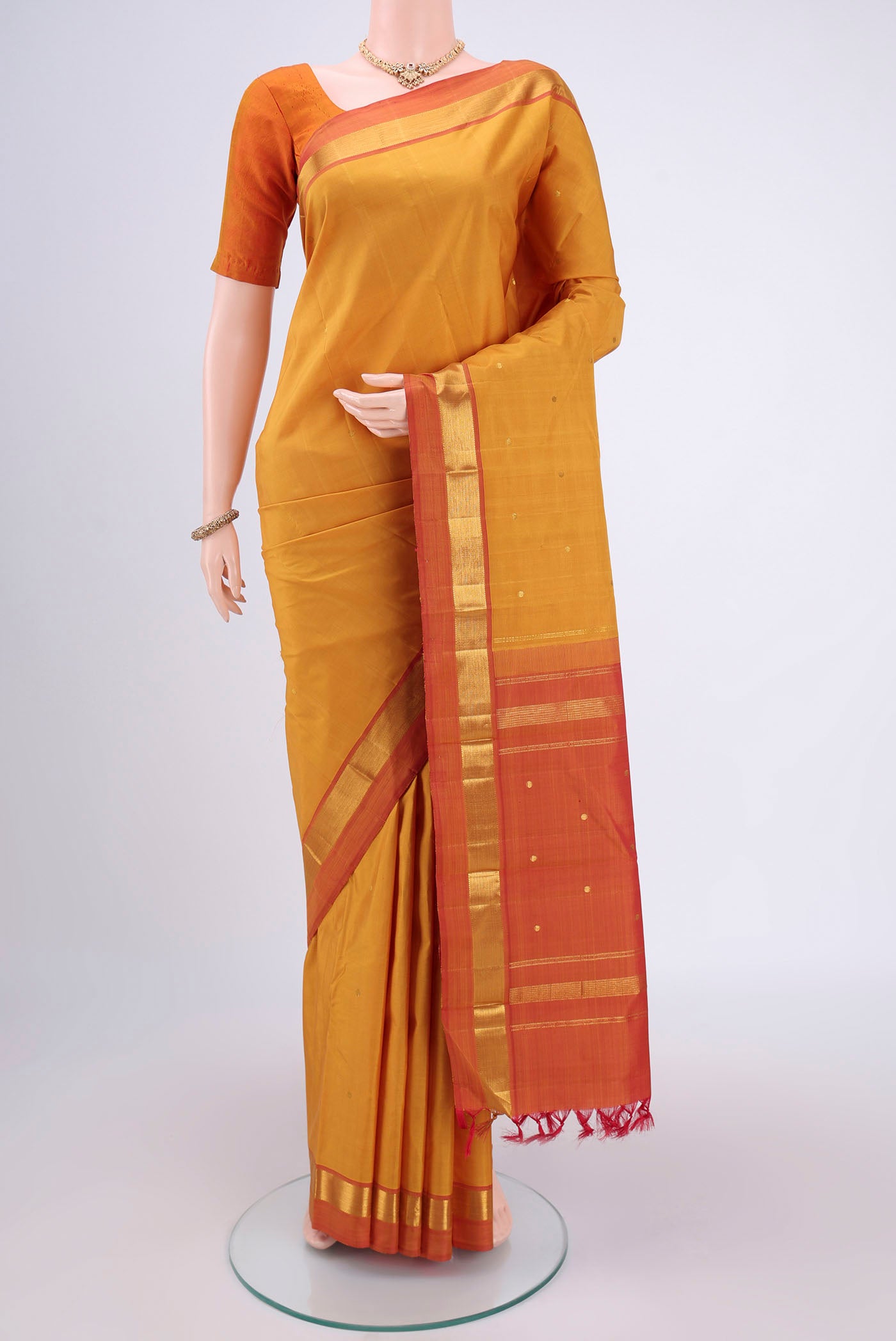 Mustard Dual Tone Kanjivaram Silk Saree with Zari Butta on the body and Zari Border.  displayed on a mannequin