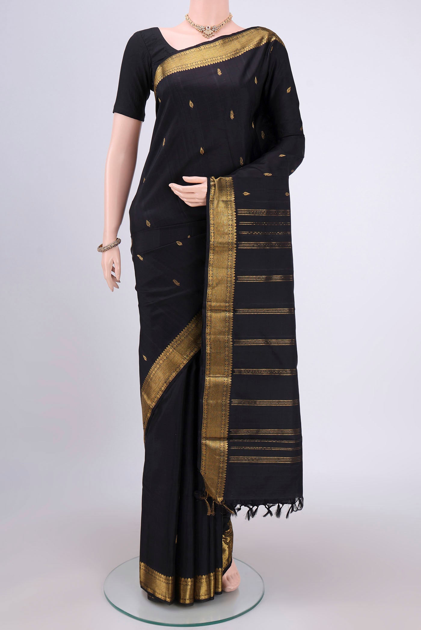 Black Kanchipuram Silk Saree with Plain Body and Zari Border.  displayed on a mannequin
