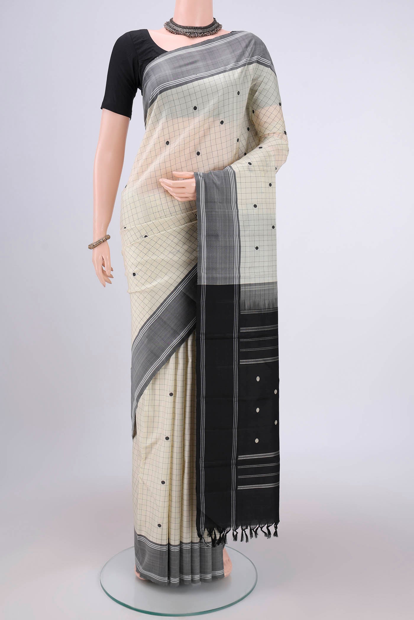 Off White Kanjivaram Saree with Checked design on the body and Plain Border.  displayed on a mannequin