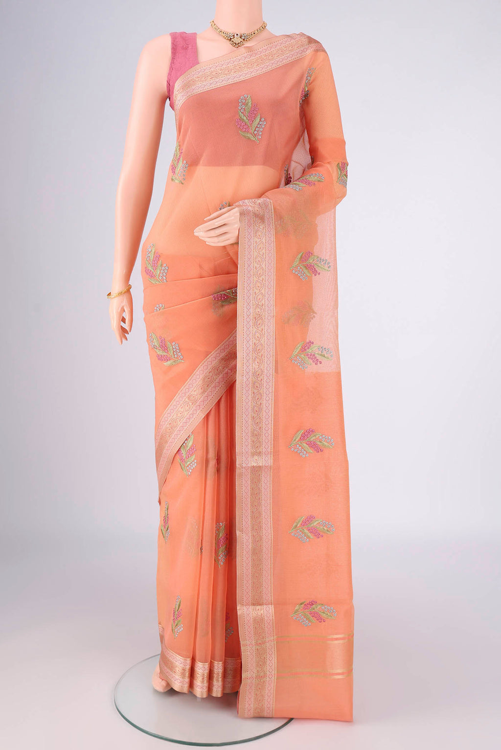 Peach Blended Kota Cotton Saree with Embroidery on the body and Zari And Thread Border.  displayed on a mannequin