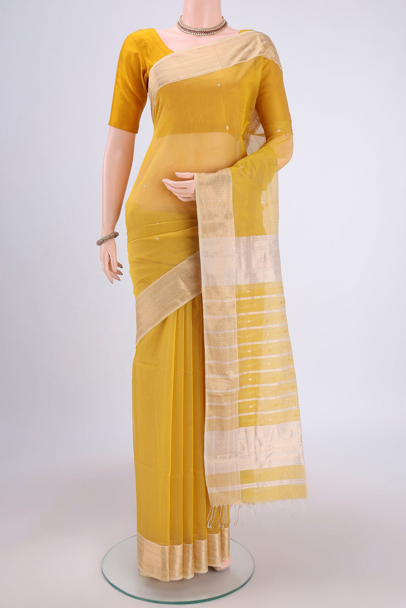 Yellow Maheshwari Silk Cotton Saree with Zari Butta on the body and Zari Border.  displayed on a mannequin