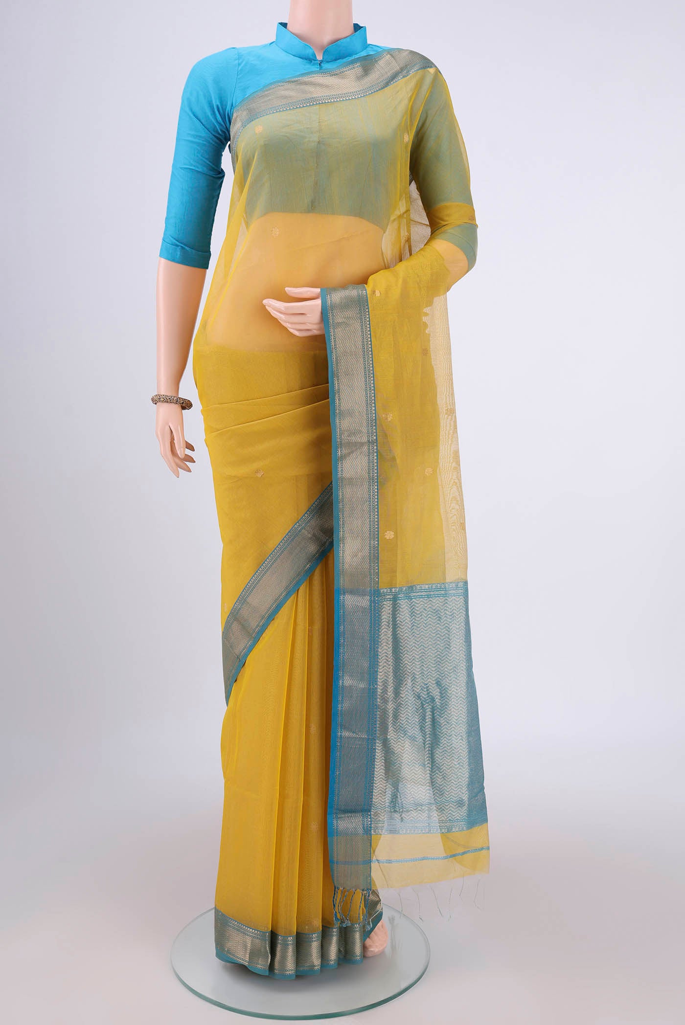 Yellow Maheshwari Silk Cotton Saree with Zari Butta on the body and Zari Border.  displayed on a mannequin