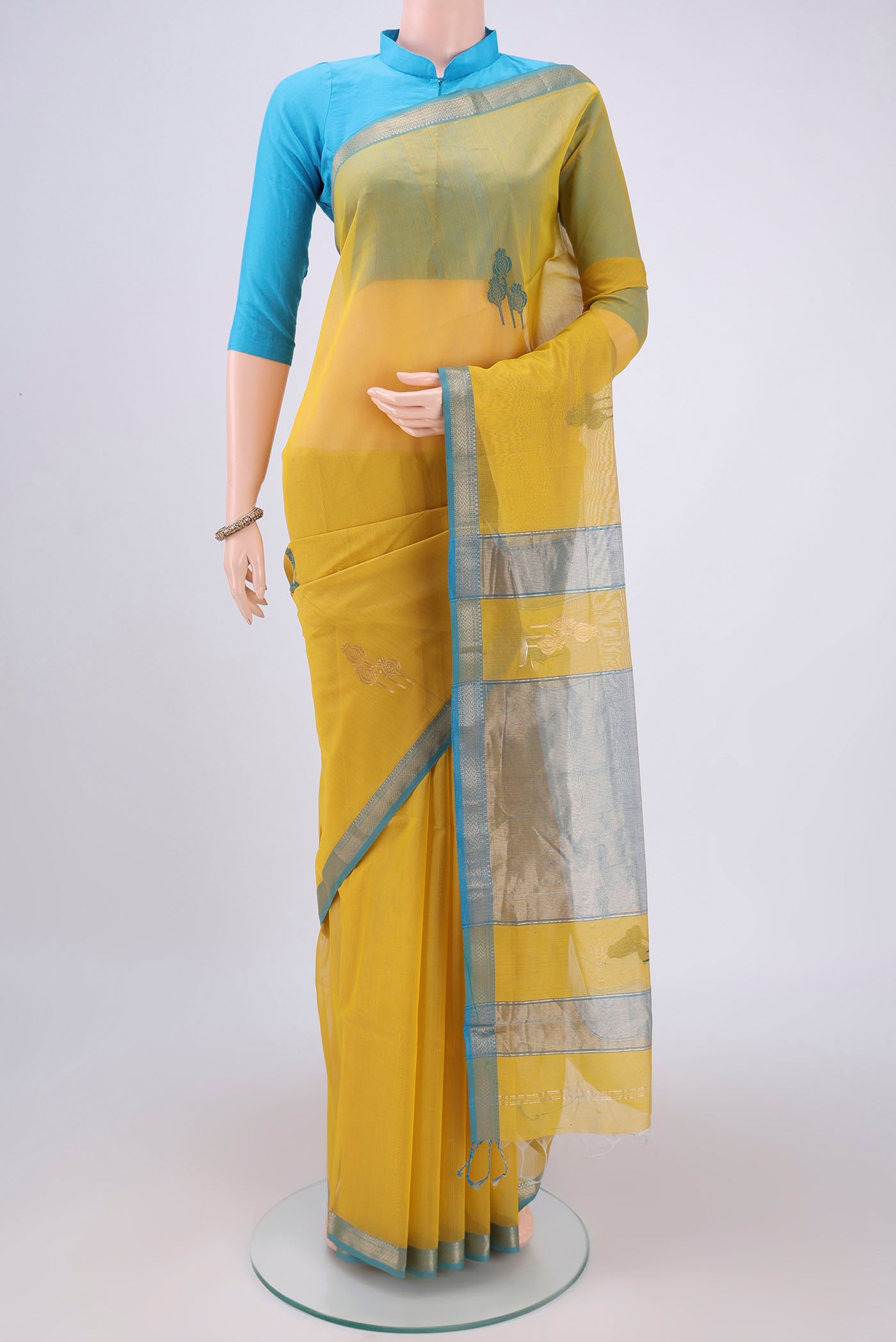 Yellow Maheshwari Silk Cotton Saree with Zari And Thread Butta on the body and Zari Border.  displayed on a mannequin