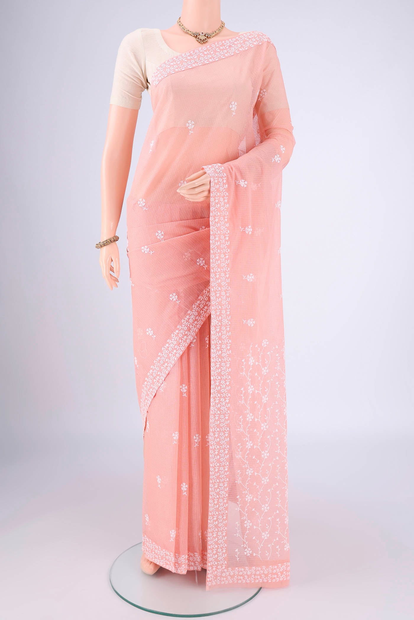 Peach Blended Kota Cotton Saree with Embroidery on the body and Checks Border.  displayed on a mannequin