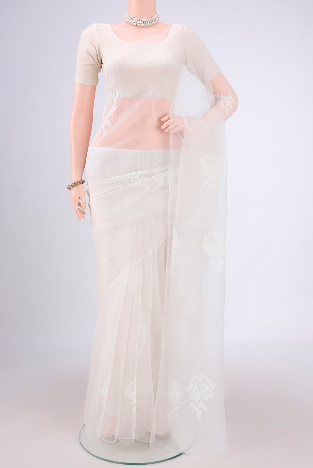 White Organza Silk Saree with Embroidery on the body and Thin Zari Line.  displayed on a mannequin