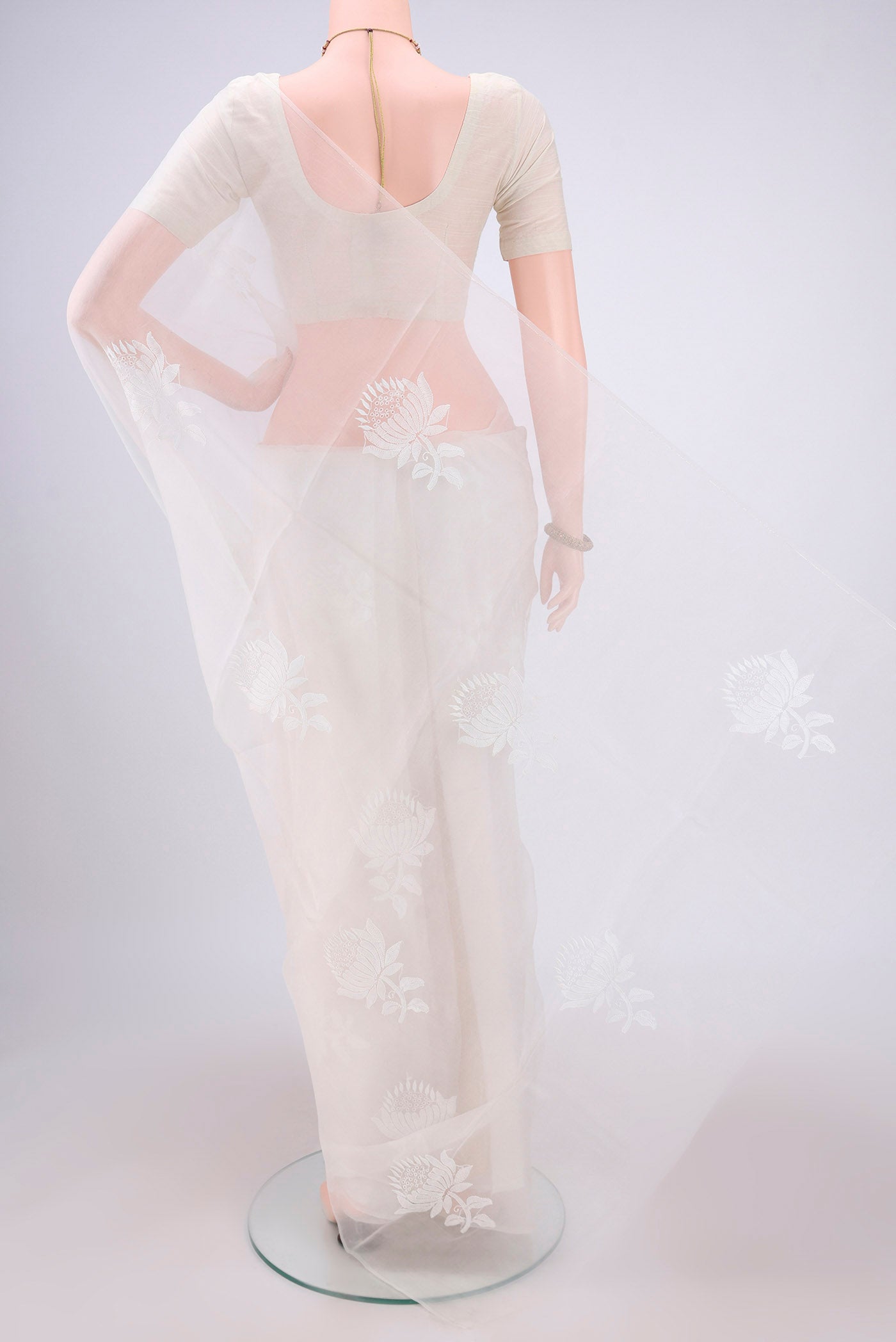 Flat view of White Organza Silk Saree with Embroidery on the body and Thin Zari Line. 