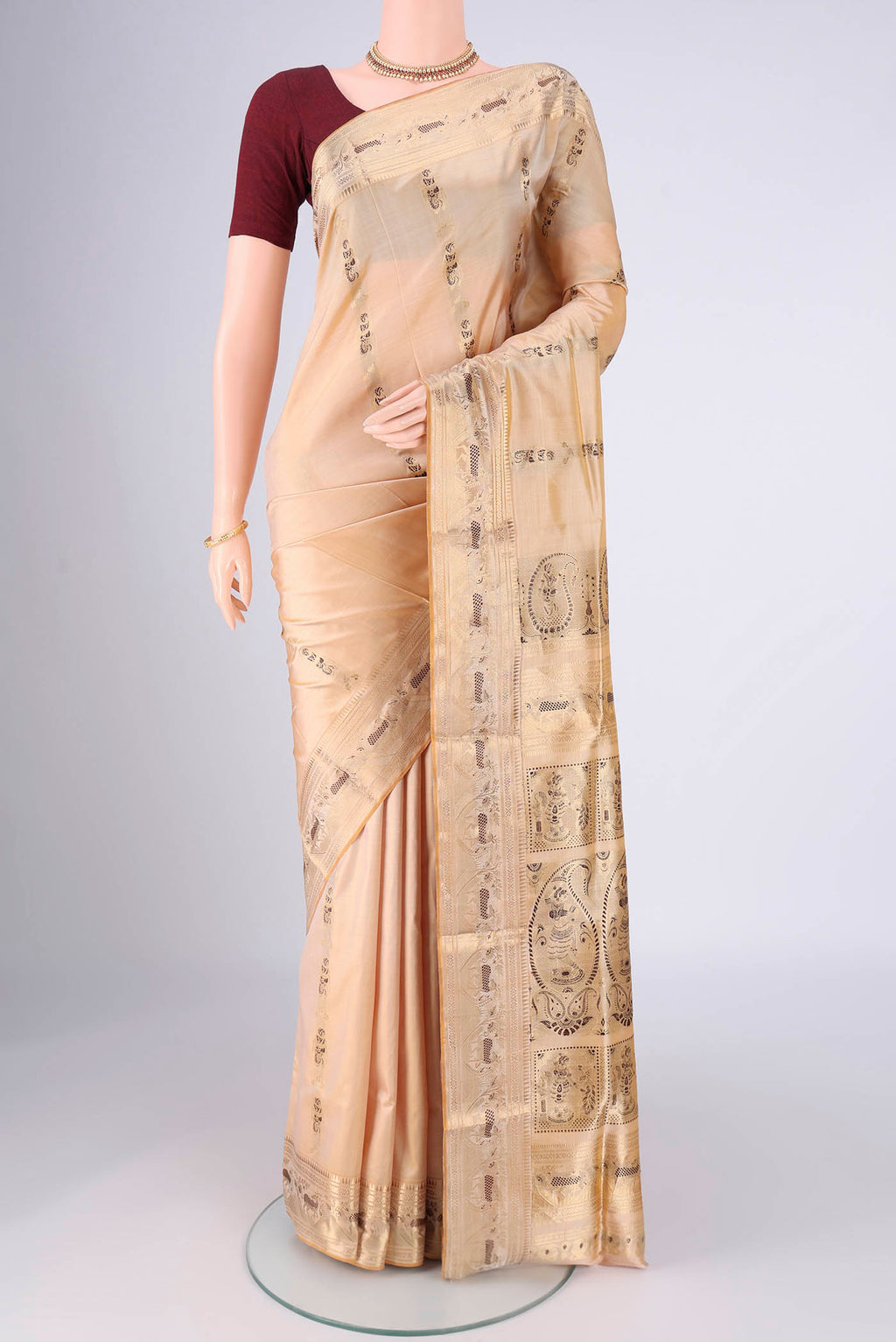 Cream Baluchari Silk Saree with Zari And Thread Butta on the body and Zari And Thread Border.  displayed on a mannequin