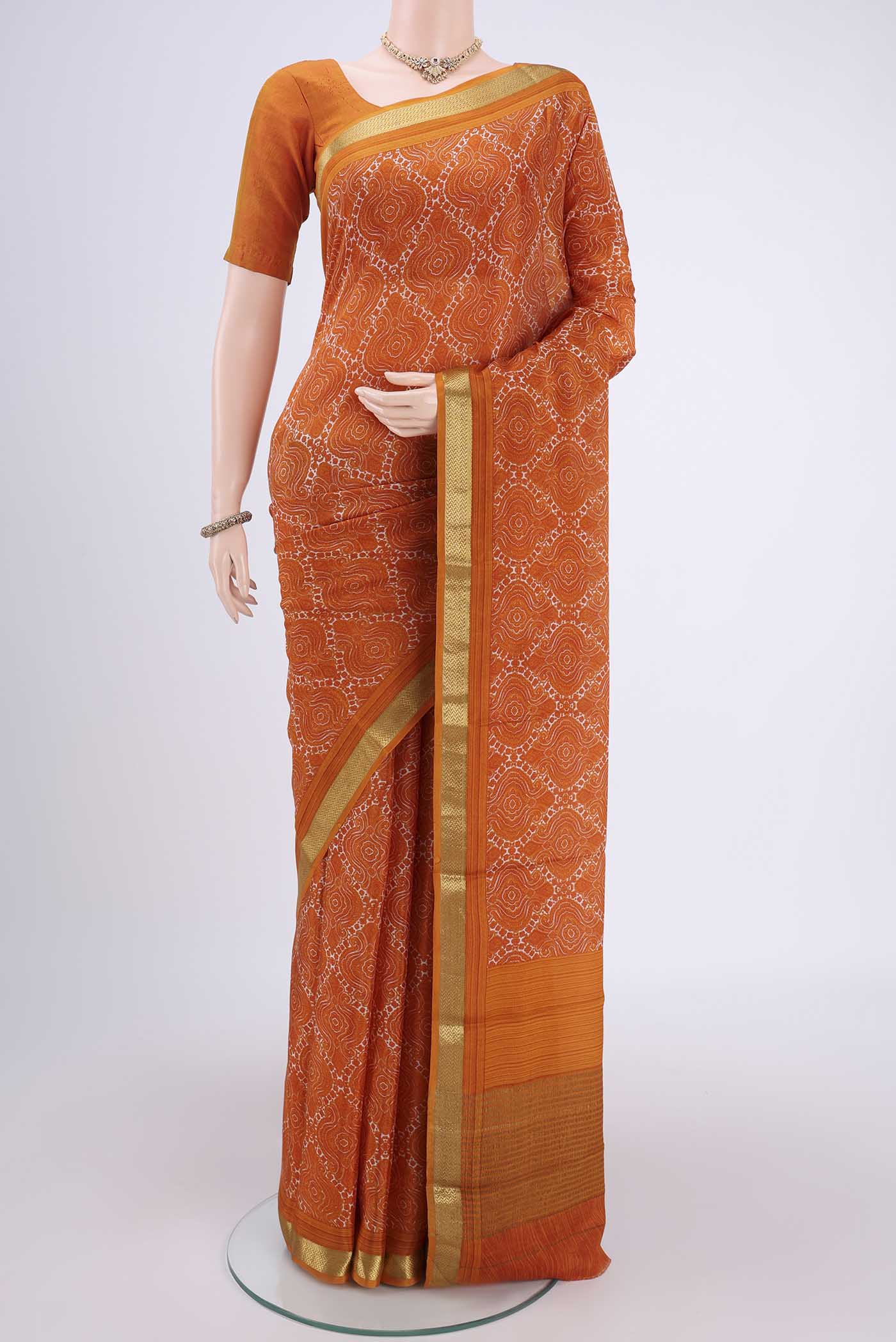 Orange Mysore Crepe Saree with Floral Print on the body and Zari Border.  displayed on a mannequin
