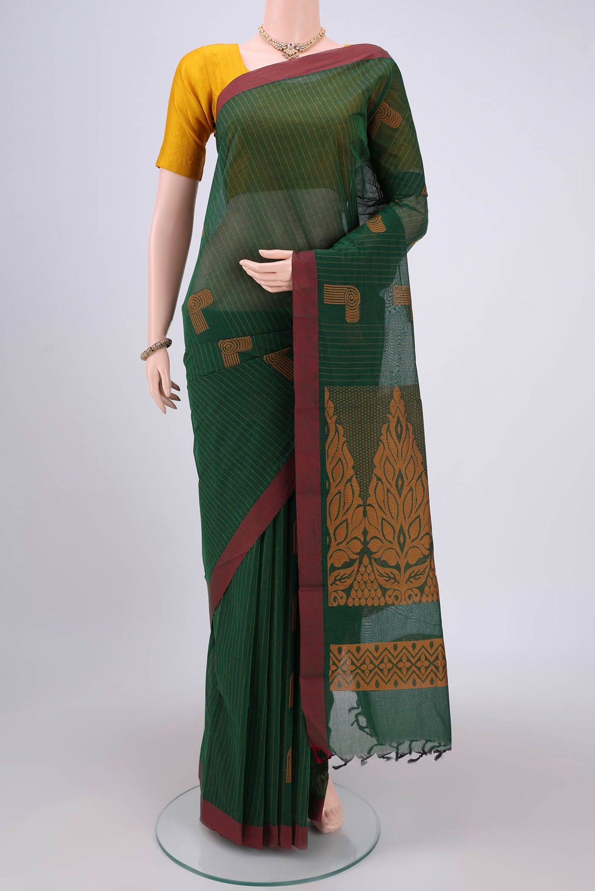 Bottle Green Kanchi Cotton Saree with Thread Butta on the body and Plain Border.  displayed on a mannequin