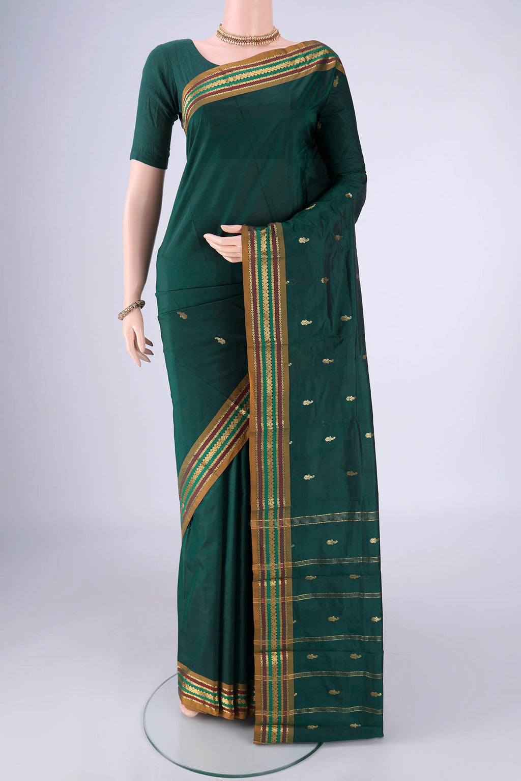 Bottle Green Blended Bangalore Silk Saree with Zari Butta on the body and Zari Border.  displayed on a mannequin