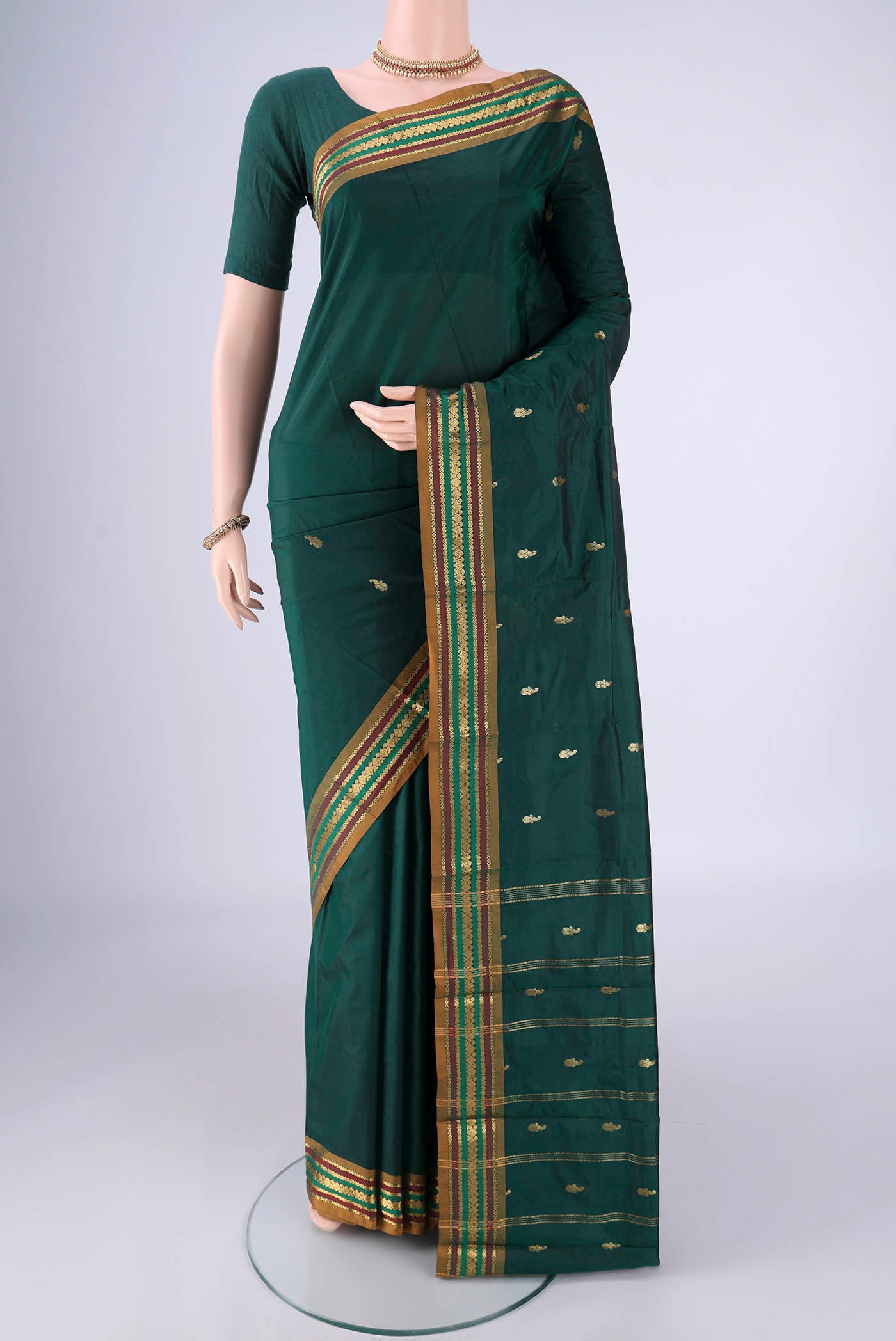 Bottle Green Blended Bangalore Silk Saree with Zari Butta on the body and Zari Border.  displayed on a mannequin