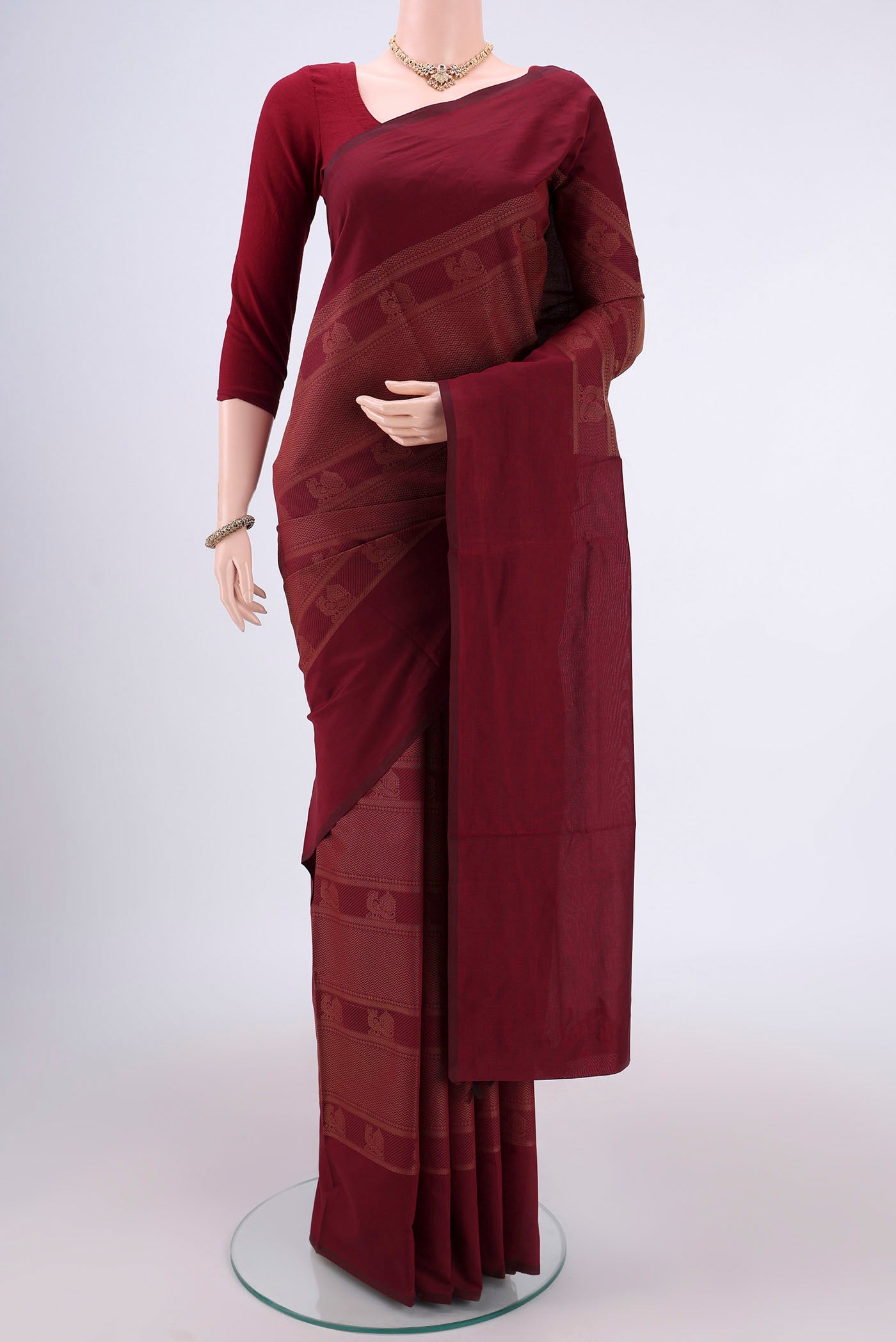 Maroon Blended Poly Cotton Saree with Jacquard design on the body and Plain Border.  displayed on a mannequin