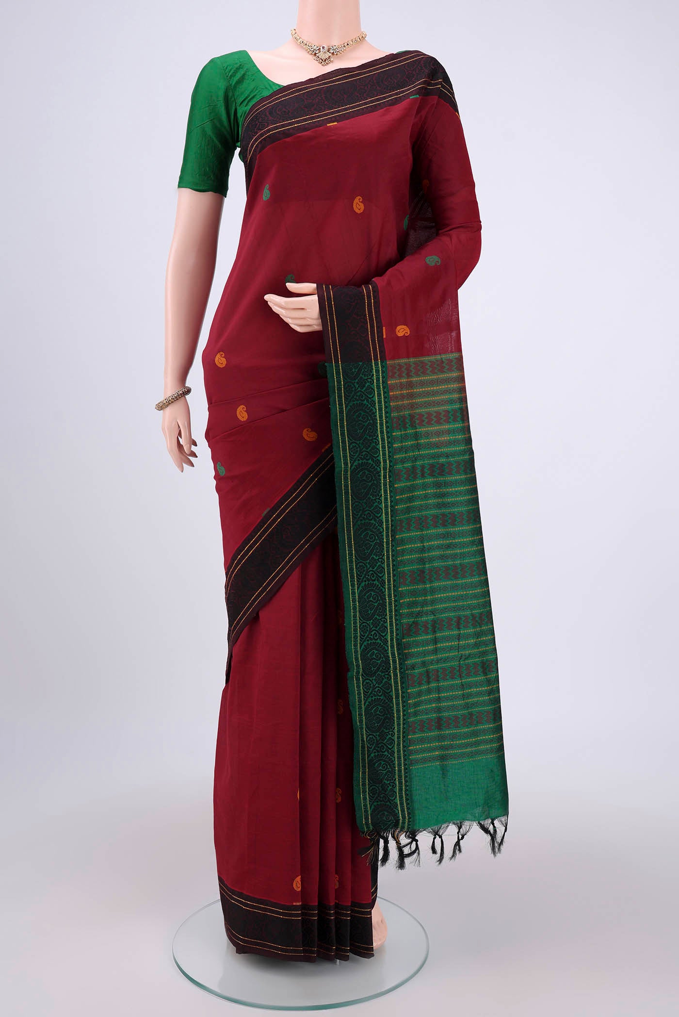 Maroon Blended Poly Cotton Saree with Thread Butta on the body and Thread Border.  displayed on a mannequin
