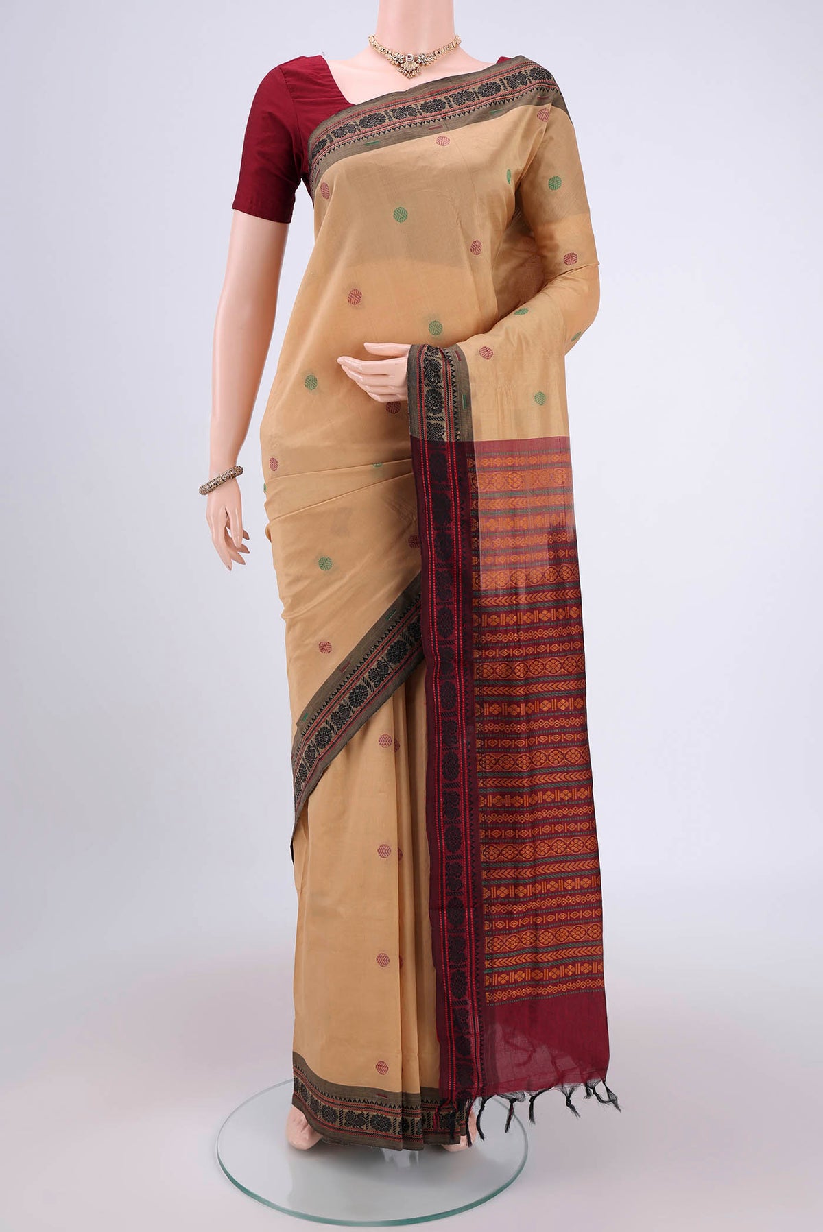 Beige Blended Poly Cotton Saree with Thread Butta on the body and Thread Border.  displayed on a mannequin