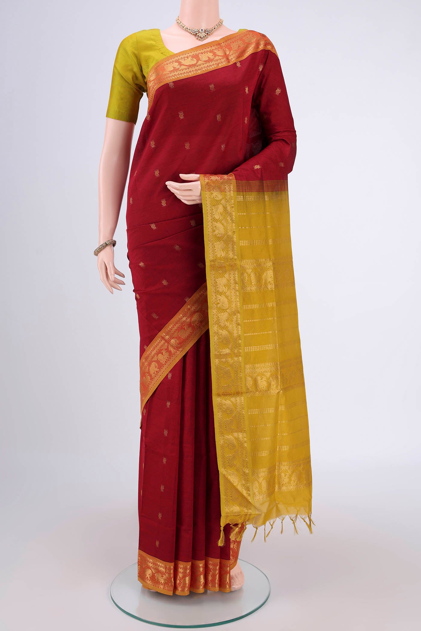 Red Blended Poly Cotton Saree with Zari Butta on the body and Zari Border.  displayed on a mannequin
