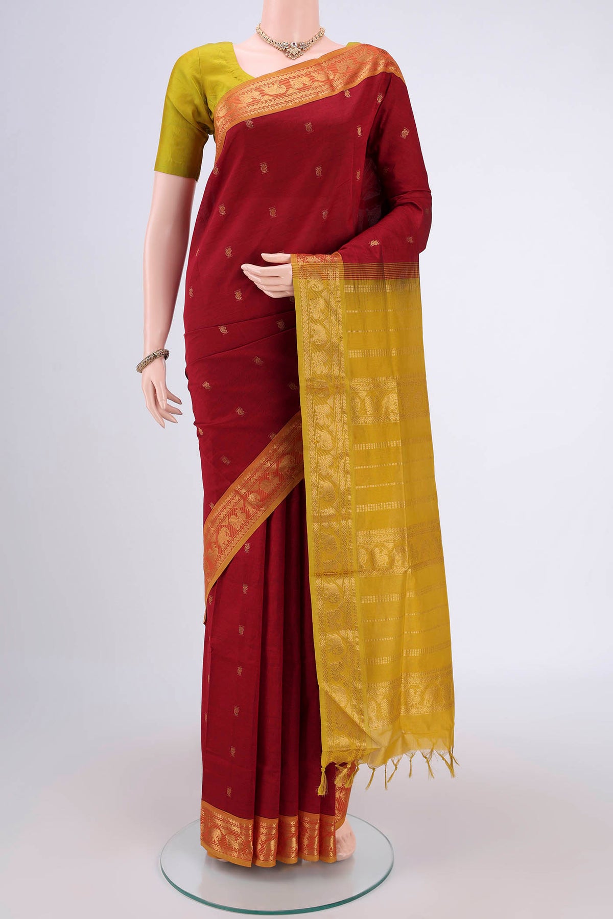 Red Blended Poly Cotton Saree with Zari Butta on the body and Zari Border.  displayed on a mannequin