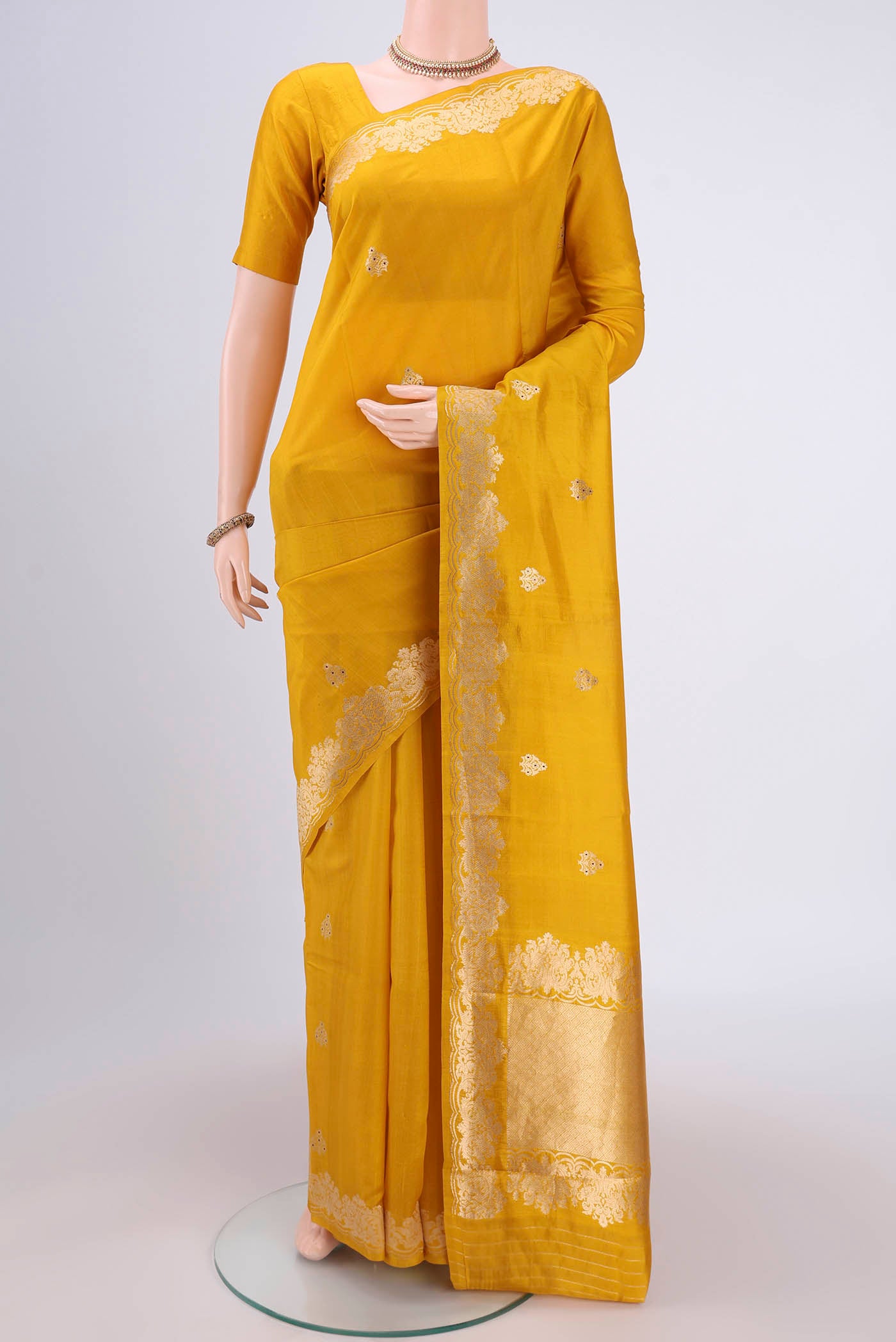 Yellow Banarasi Katan Silk Saree with Zari Butta on the body and Zari Border.  displayed on a mannequin