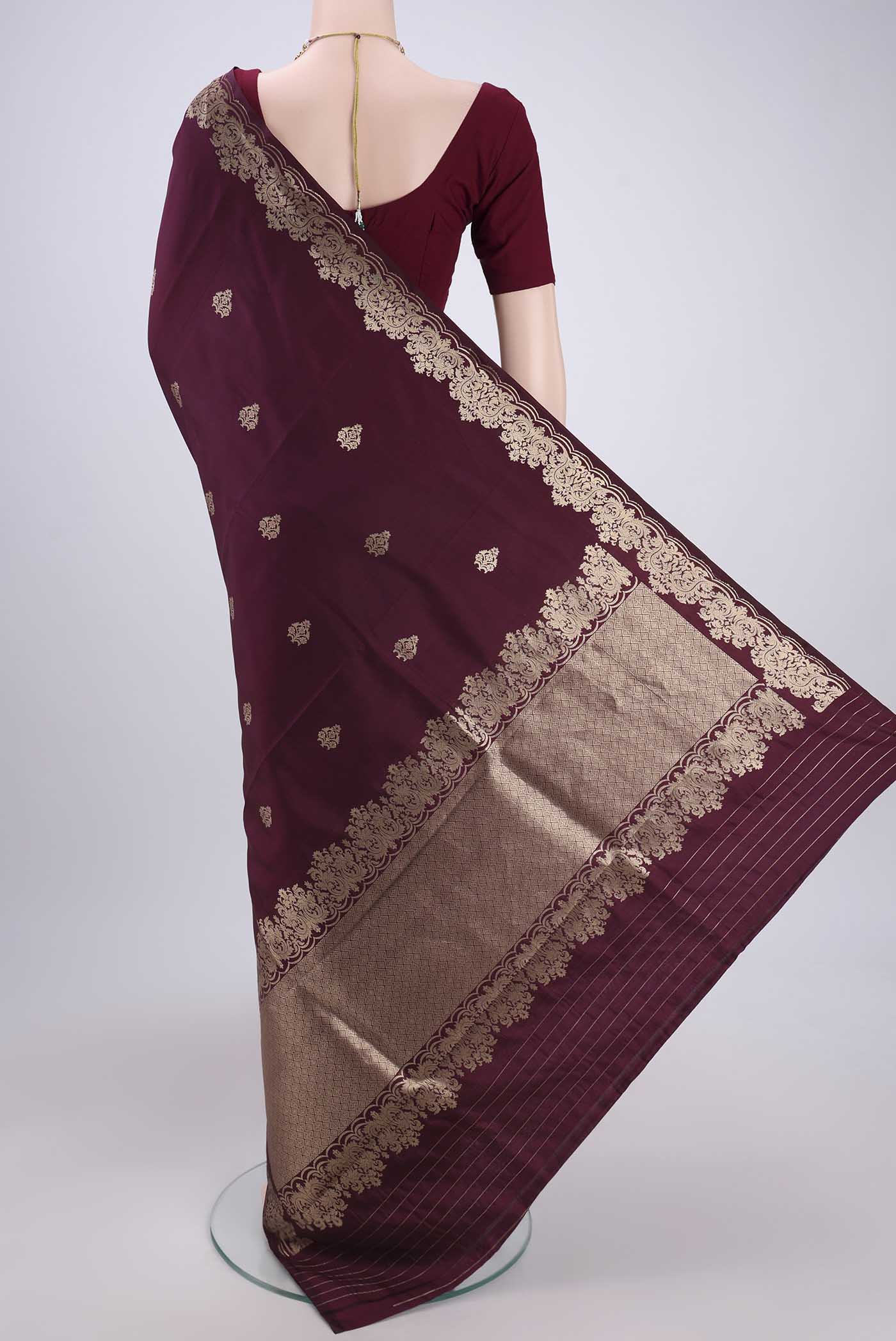 Flat view of Burgundy Banarasi Katan Silk Saree with Zari Butta on the body and Zari Border. 