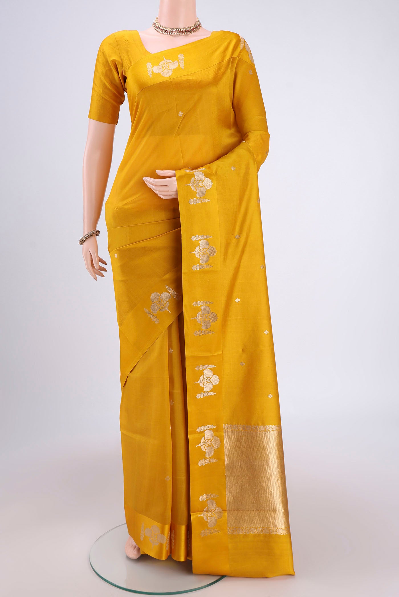 Yellow Banarasi Katan Silk Saree with Zari Butta on the body and Zari Border.  displayed on a mannequin