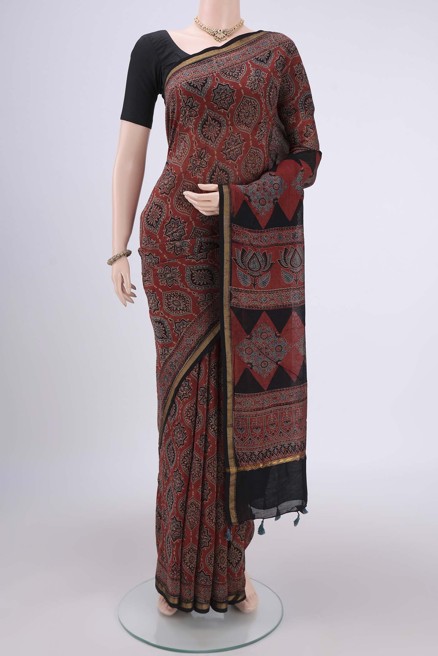 Maroon Chanderi Silk Cotton Saree with Ajrakh Print on the body and Zari Border.  displayed on a mannequin