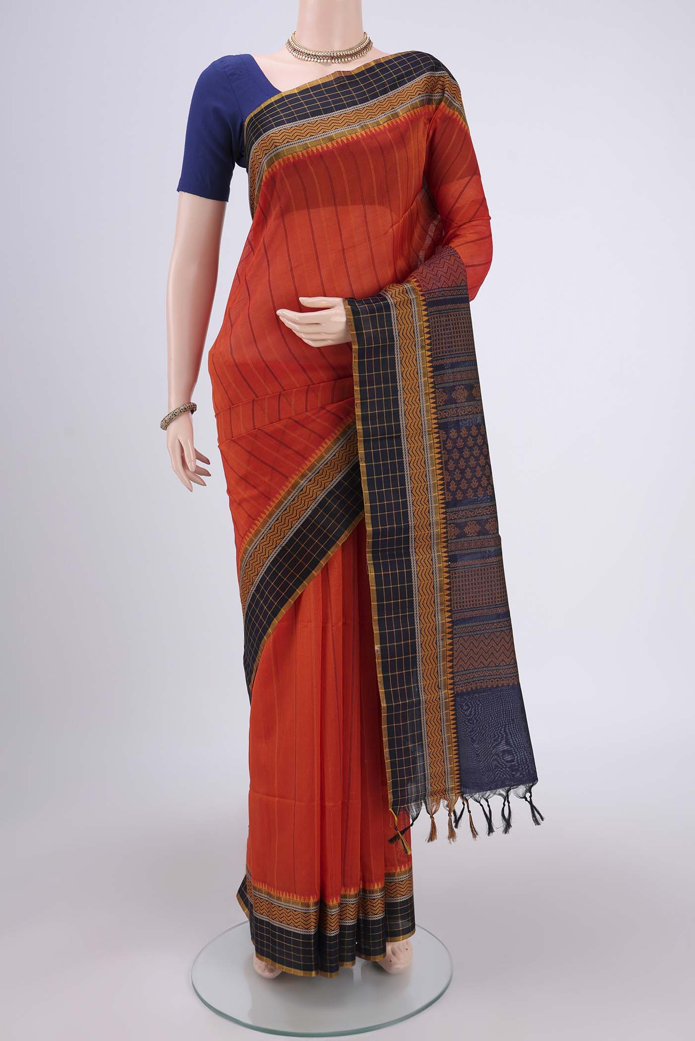 Orange Silk Cotton Saree with Stripes on the body and Thread Border.  displayed on a mannequin