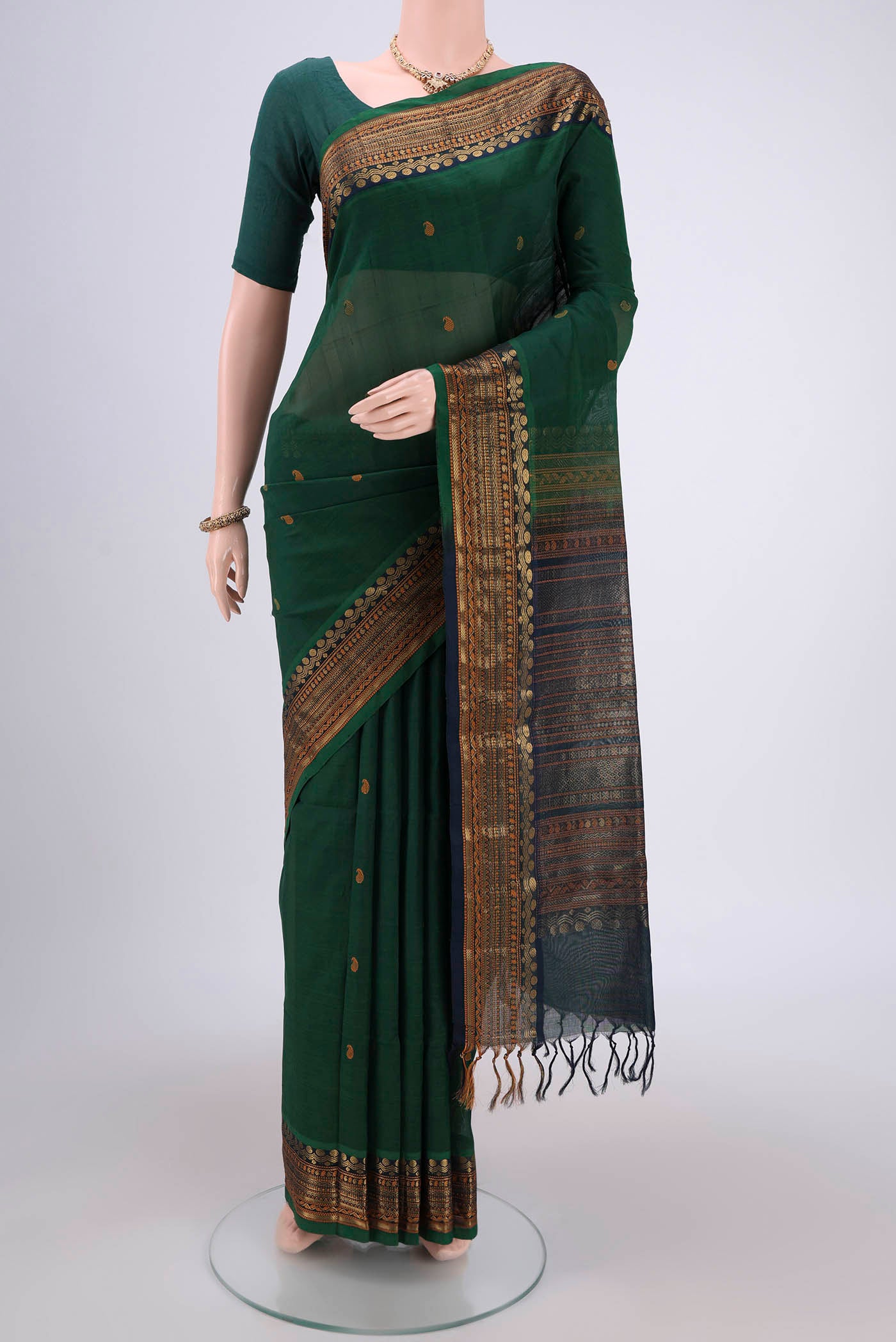 Bottle Green Coimbatore Silk Cotton Saree with Zari Butta on the body and Plain Border.  displayed on a mannequin