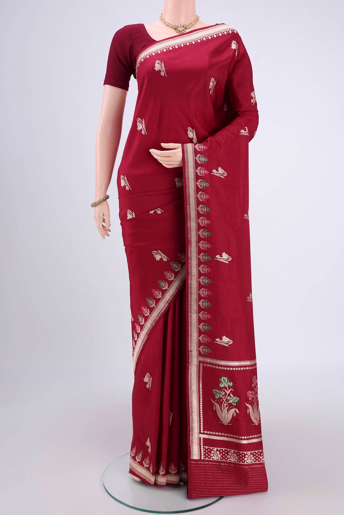 Maroon Banarasi Saree with Zari Butta on the body and Zari And Thread Border.  displayed on a mannequin