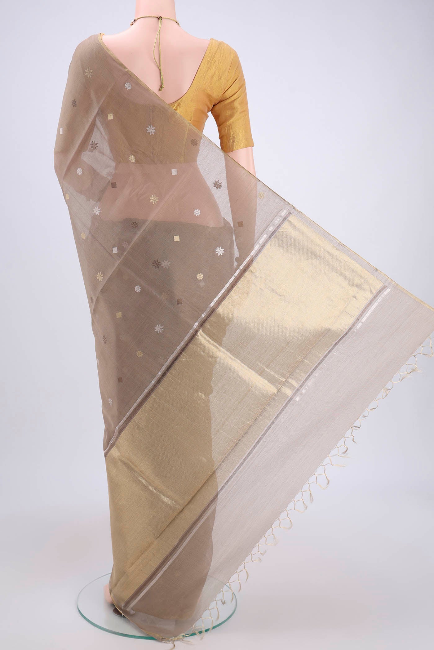 Flat view of Beige MP Tussar Saree with Zari Butta on the body and Zari Border. 