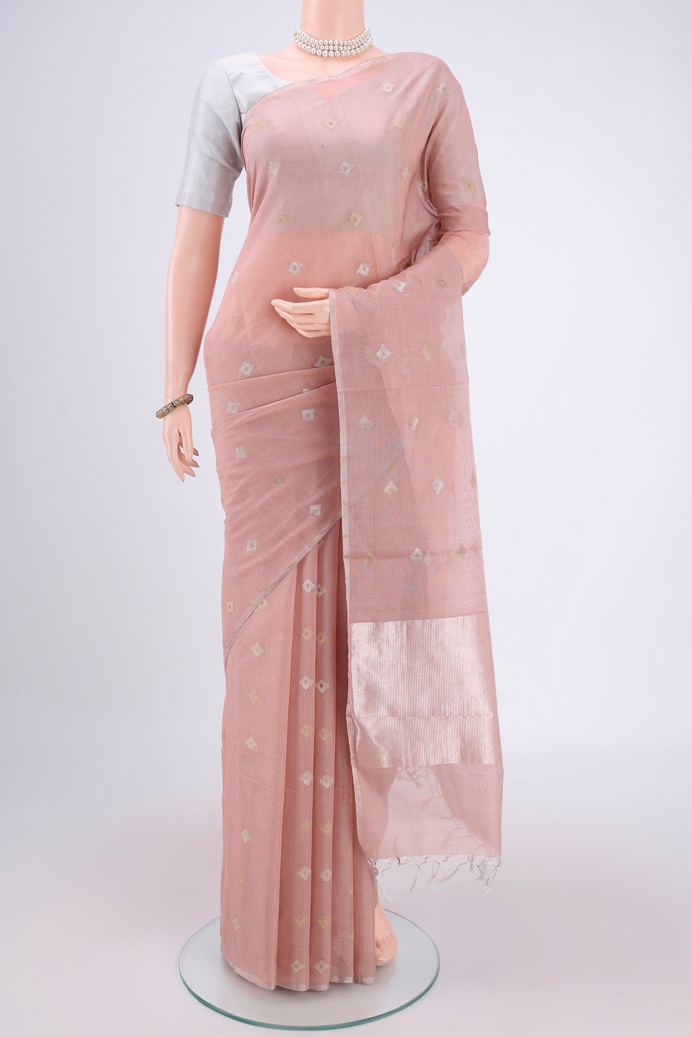 Peach MP Tussar Saree with Zari Butta on the body and Zari Border.  displayed on a mannequin