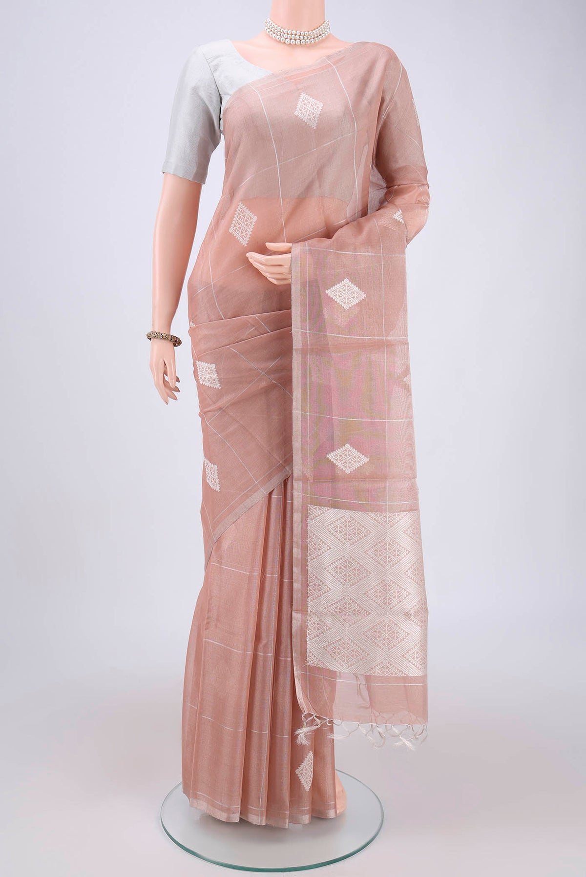 Peach MP Tussar Saree with Zari Butta on the body and Zari Border.  displayed on a mannequin