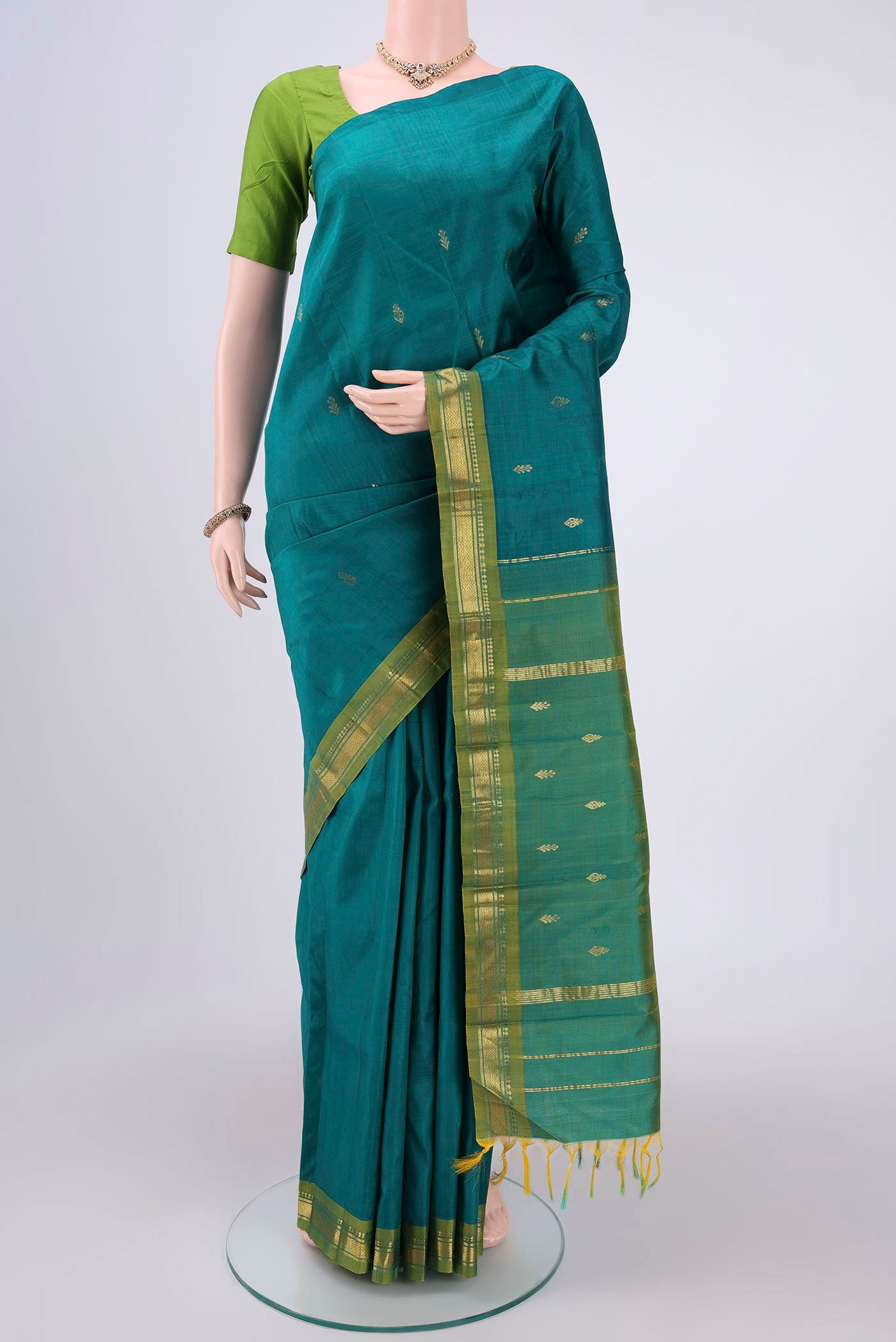 Sea Green Kanchipuram Silk Saree with Zari Butta on the body and Zari Border.  displayed on a mannequin
