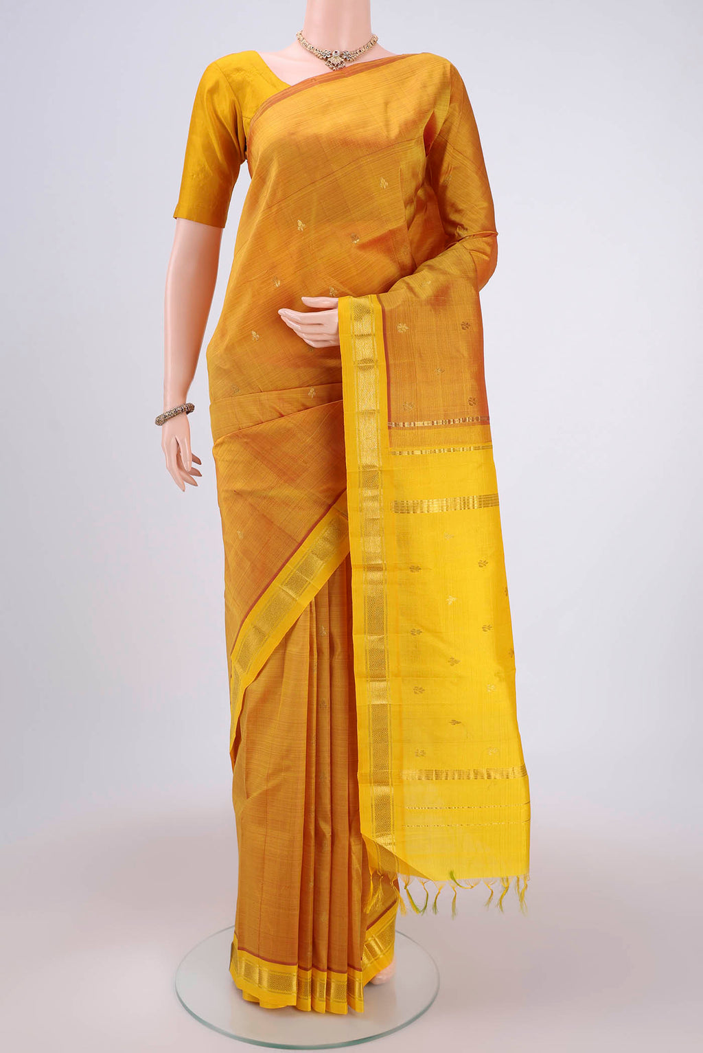 Yellow Kanchipuram Silk Saree with Zari Butta on the body and One Side Border.  displayed on a mannequin