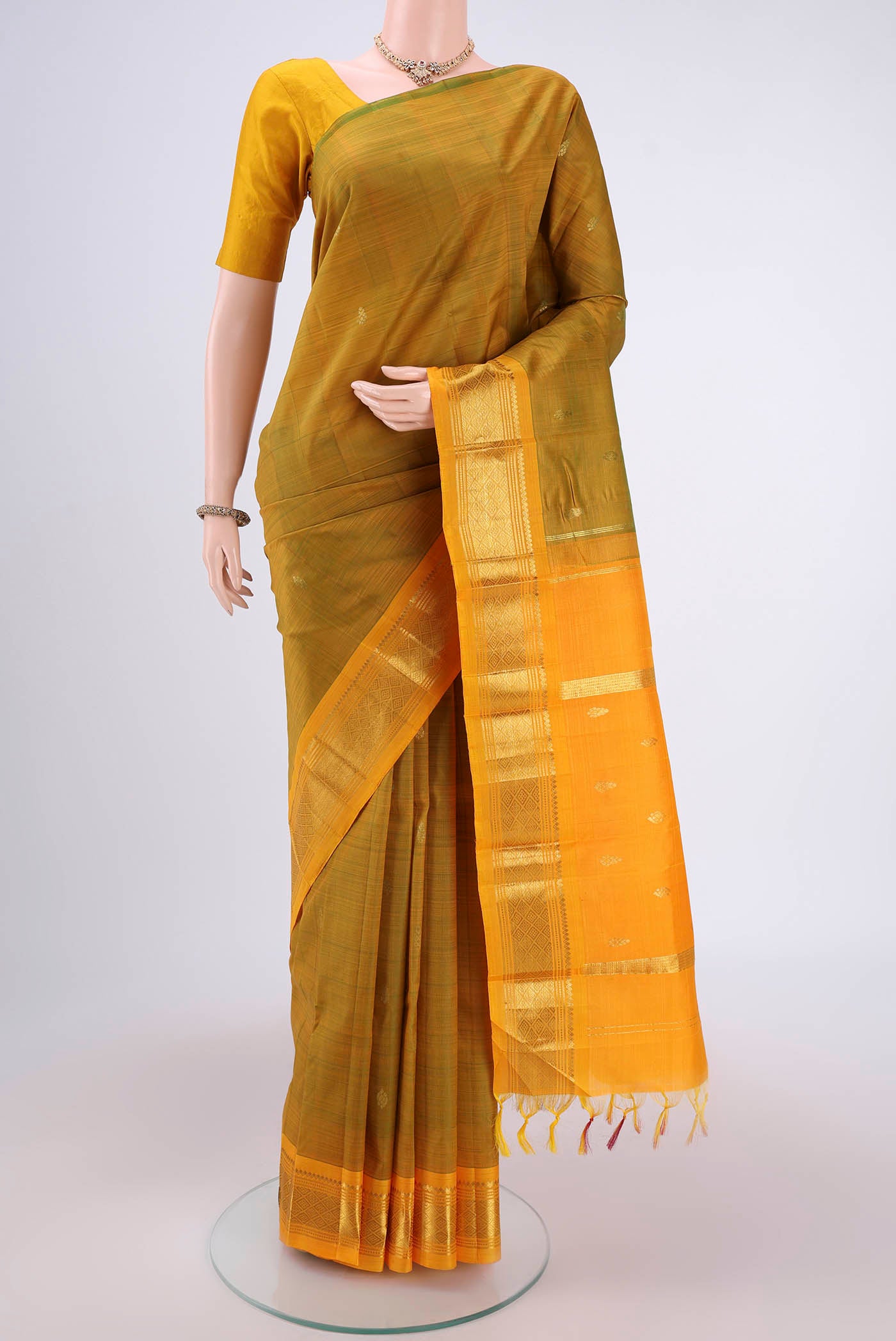 Mehandi Green Dual Tone Kanjivaram Silk Saree with Zari Butta on the body and One Side Border.  displayed on a mannequin