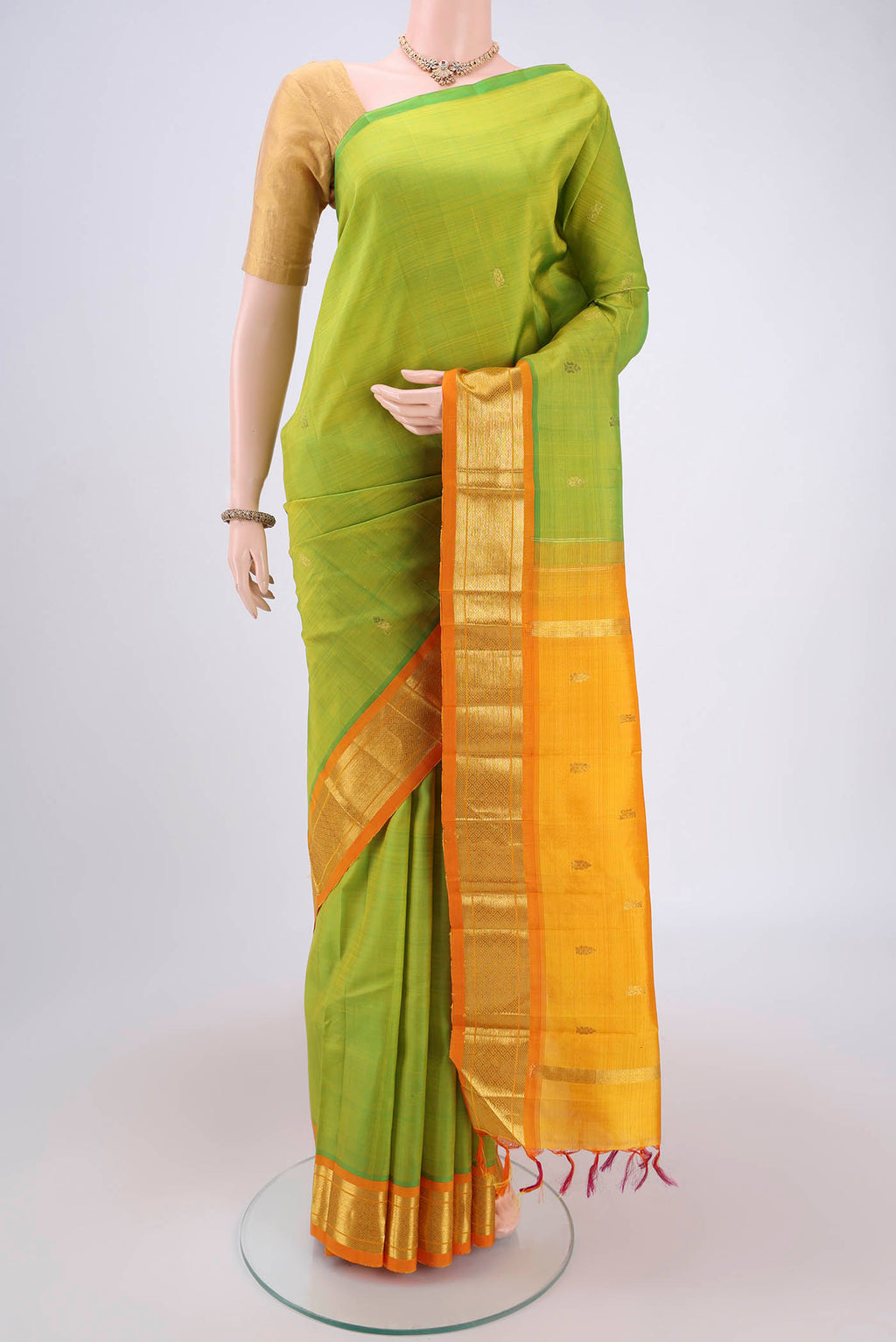 Green Kanjivaram Silk Saree with Zari Butta on the body and One Side Border.  displayed on a mannequin