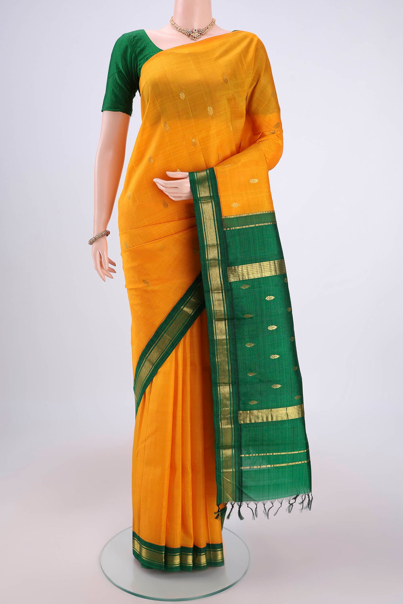 Yellow Kanjivaram Silk Saree with Zari Butta on the body and One Side Border.  displayed on a mannequin