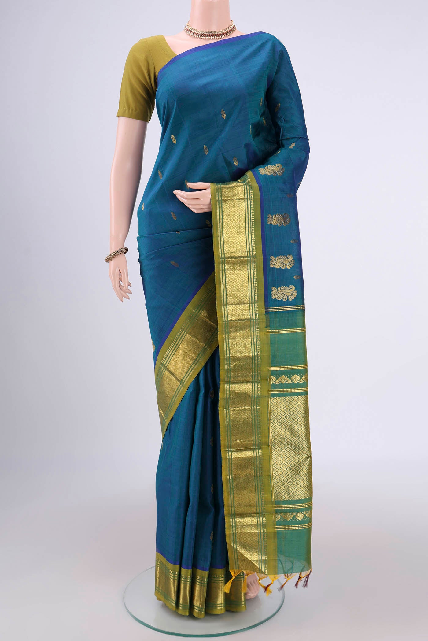 Peacock Blue Kanjivaram Silk Saree with Zari Butta on the body and One Side Border.  displayed on a mannequin