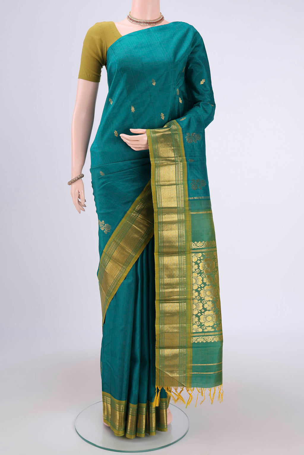 Green Kanjivaram Silk Saree with Zari Butta on the body and One Side Border.  displayed on a mannequin