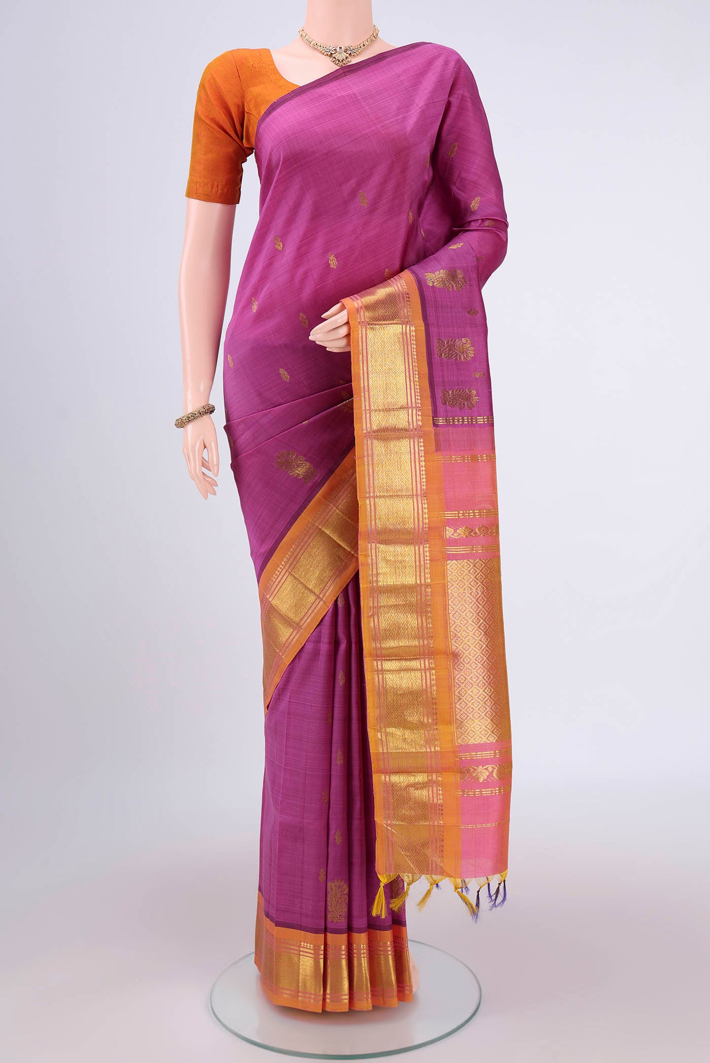 Magenta Kanjivaram Silk Saree with Zari Butta on the body and One Side Border.  displayed on a mannequin