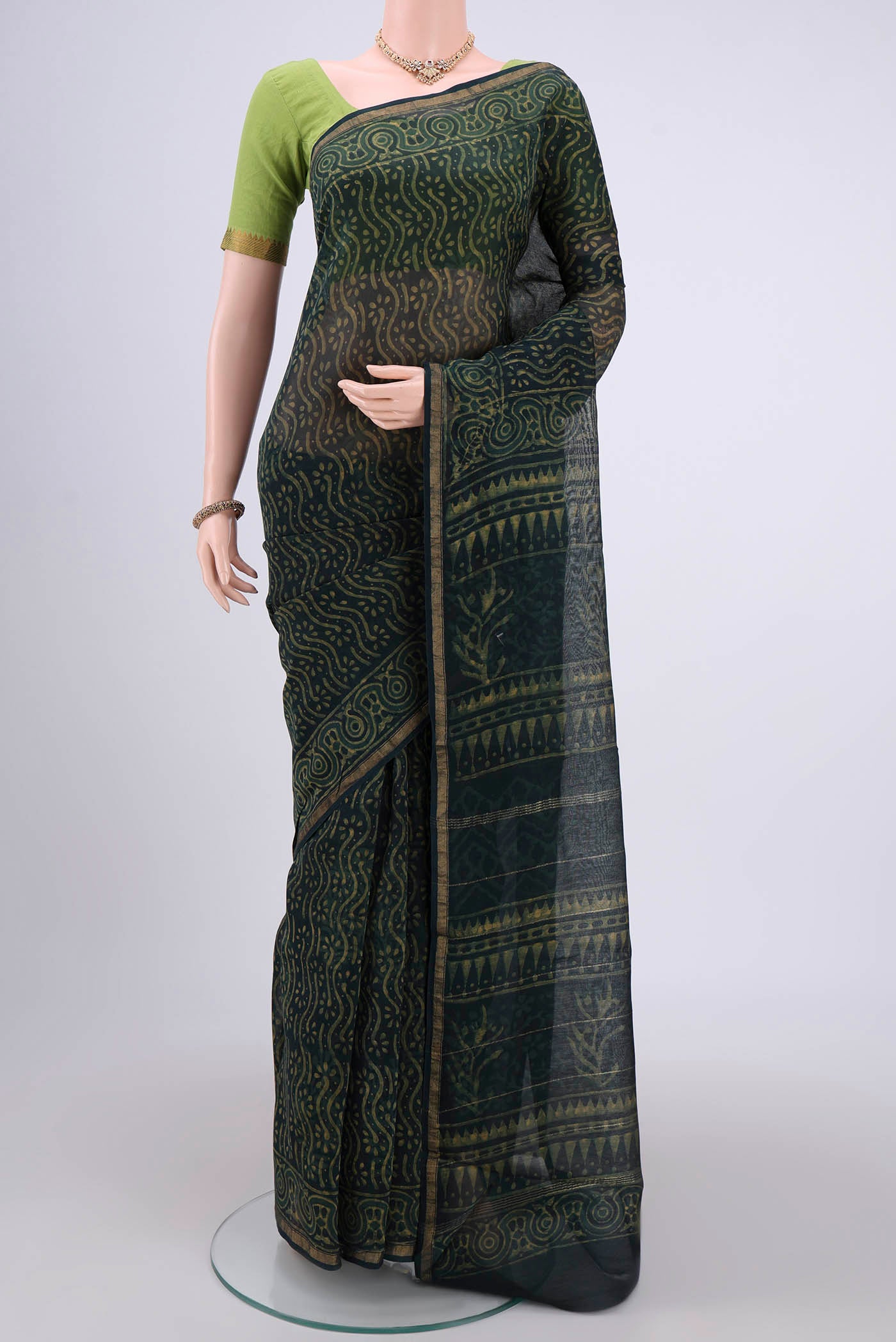 Bottle Green Maheshwari Silk Cotton Saree with Batik Print on the body and Zari Border.  displayed on a mannequin