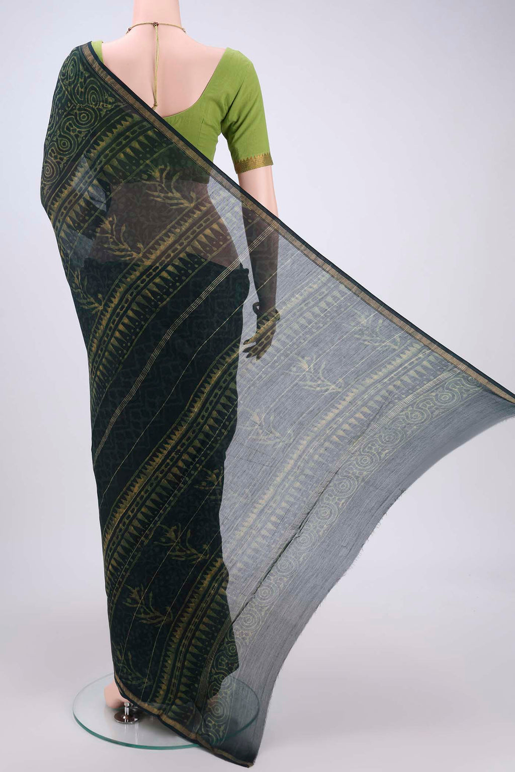 Flat view of Bottle Green Maheshwari Silk Cotton Saree with Batik Print on the body and Zari Border. 