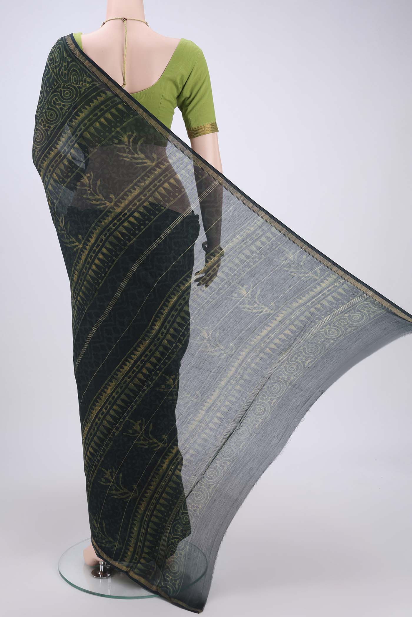Flat view of Bottle Green Maheshwari Silk Cotton Saree with Batik Print on the body and Zari Border. 