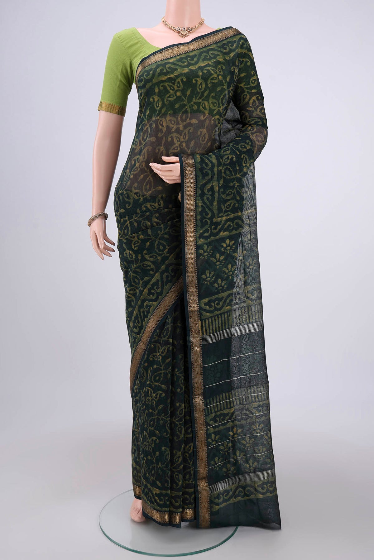 Bottle Green Maheshwari Silk Cotton Saree with Batik Print on the body and Zari Border.  displayed on a mannequin