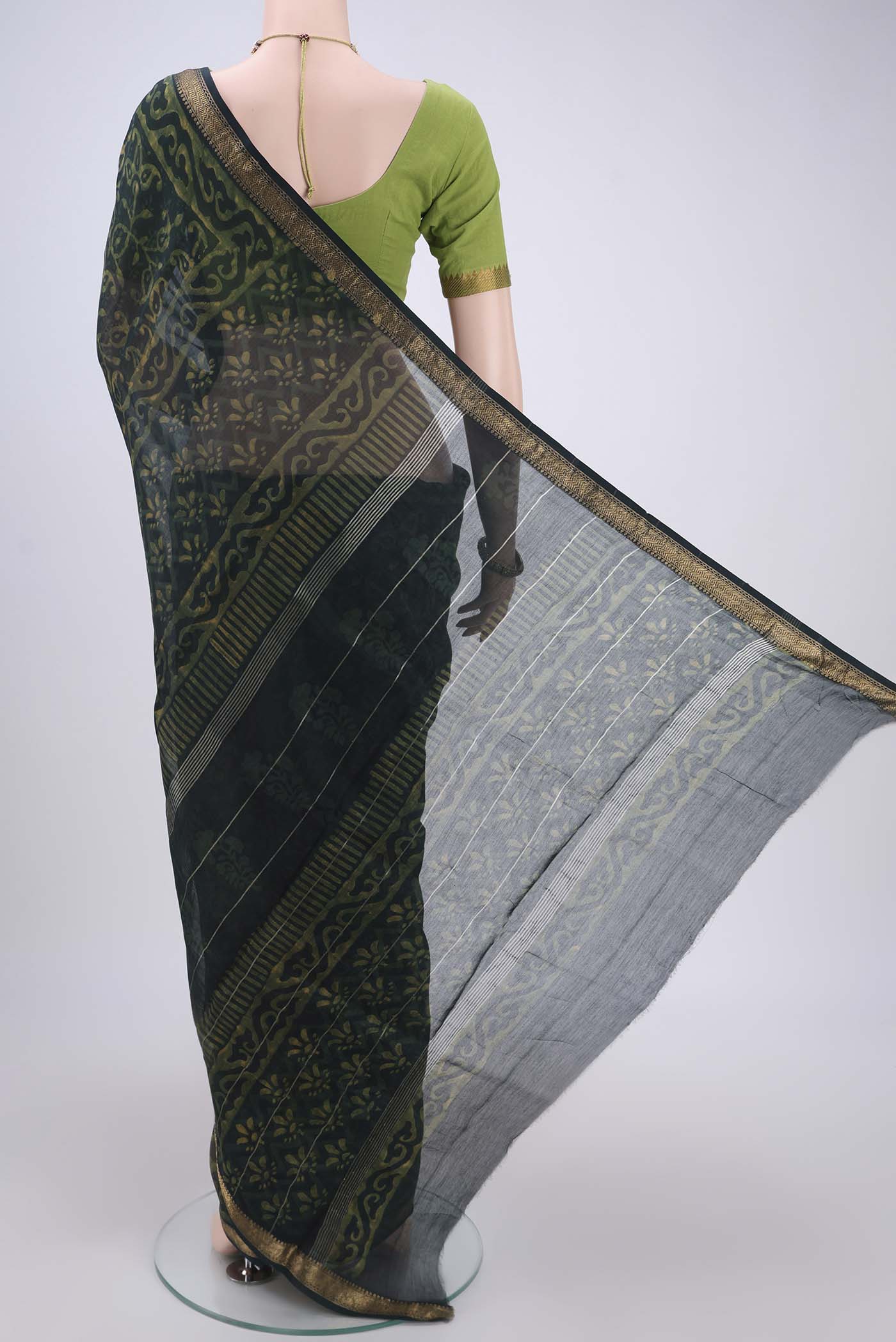 Flat view of Bottle Green Maheshwari Silk Cotton Saree with Batik Print on the body and Zari Border. 