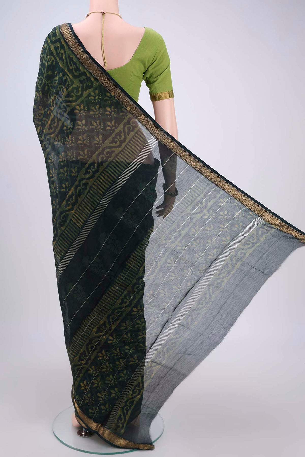 Flat view of Bottle Green Maheshwari Silk Cotton Saree with Batik Print on the body and Zari Border. 