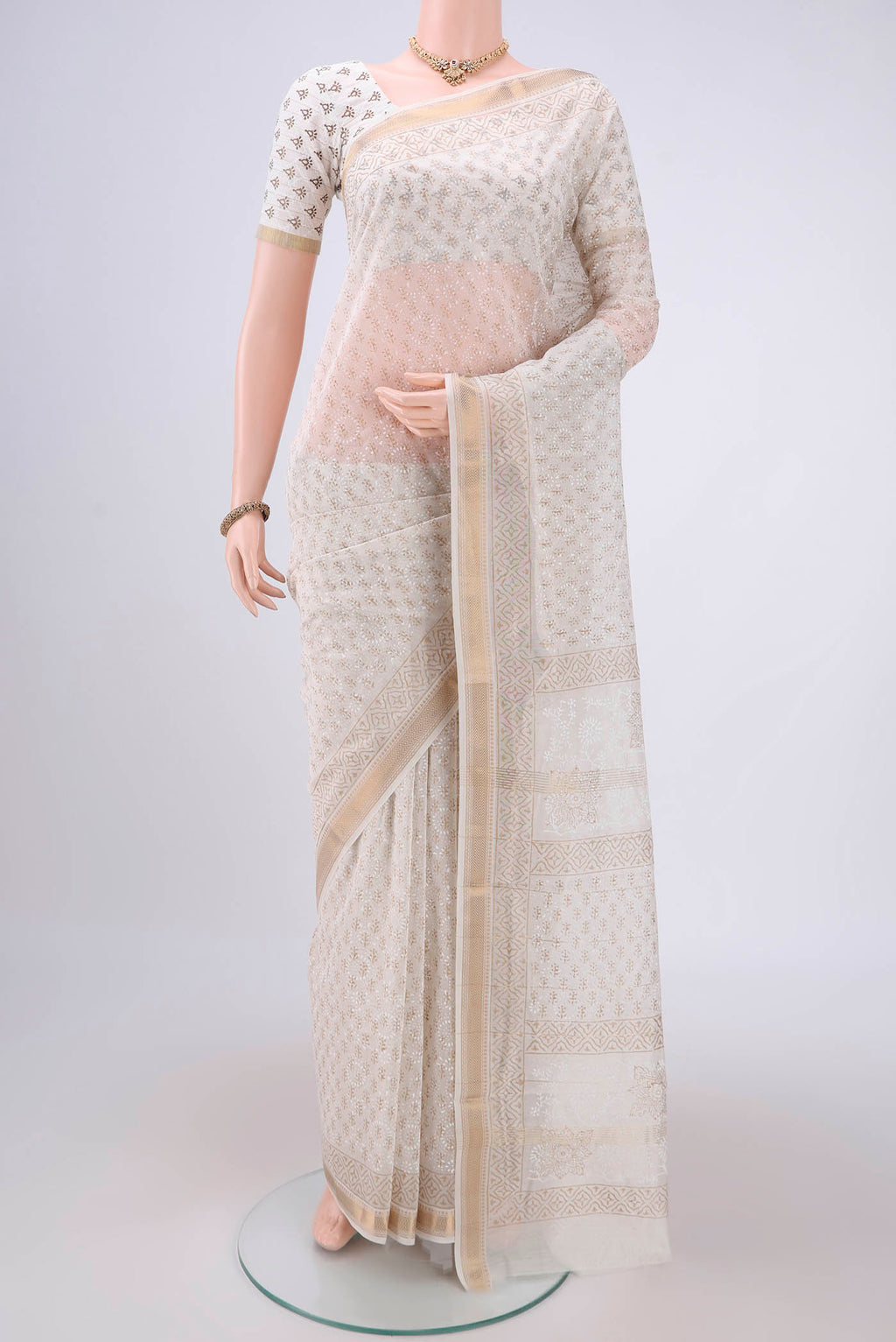 Off White Maheshwari Silk Cotton Saree with Batik Print on the body and Zari Border.  displayed on a mannequin